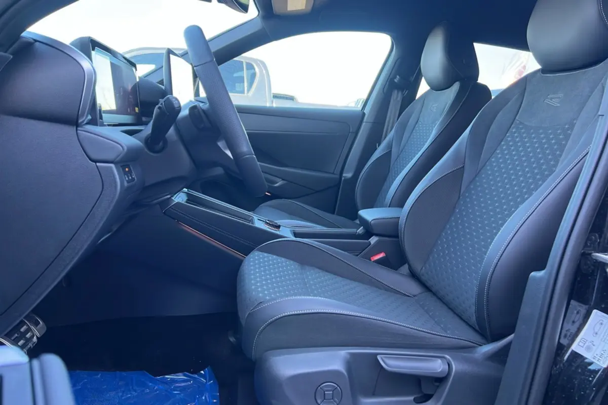 Vue intérieure côté conducteur du Volkswagen T-Roc 2026 R-Line avec sièges tissu noirs et volant cuir multifonctions.