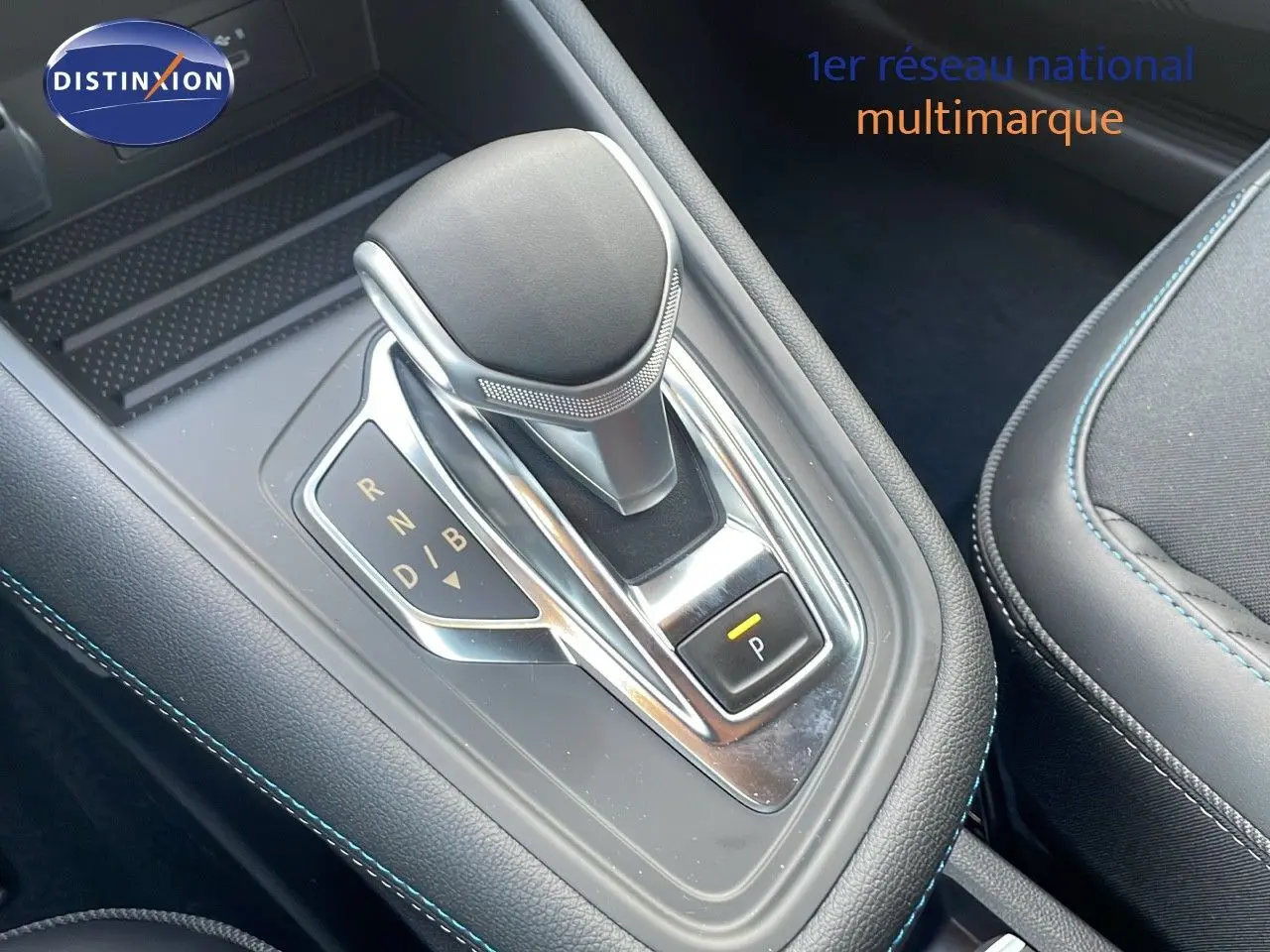Le levier de vitesses automatique du Renault Captur E-Tech hybride, avec coutures bleues sur la console noire.