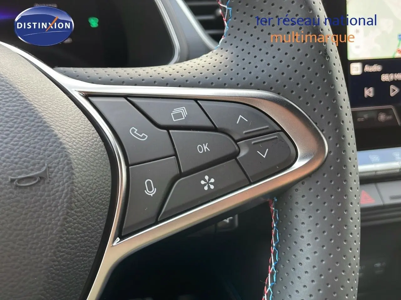 Gros plan sur le volant en cuir perforé noir avec surpiqûres tricolores du Renault Captur E-Tech hybride 2025.