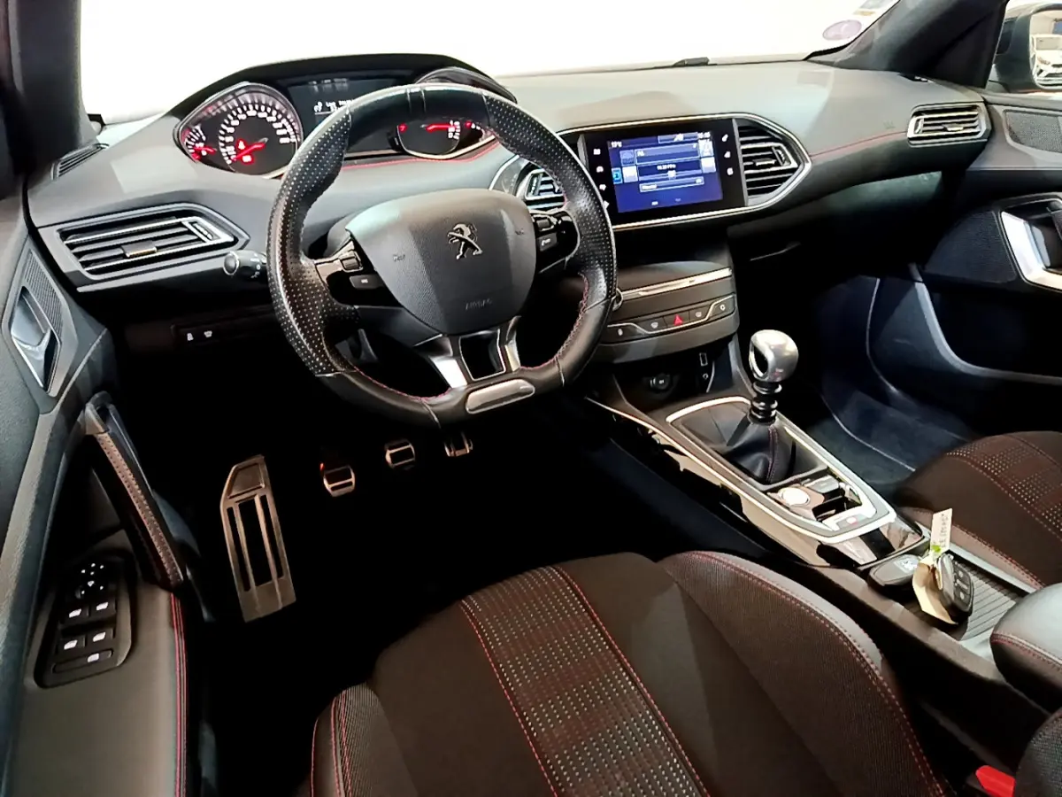 Intérieur noir de la Peugeot 308 GT Line 2016, vue côté conducteur, volant cuir et écran tactile central visible.