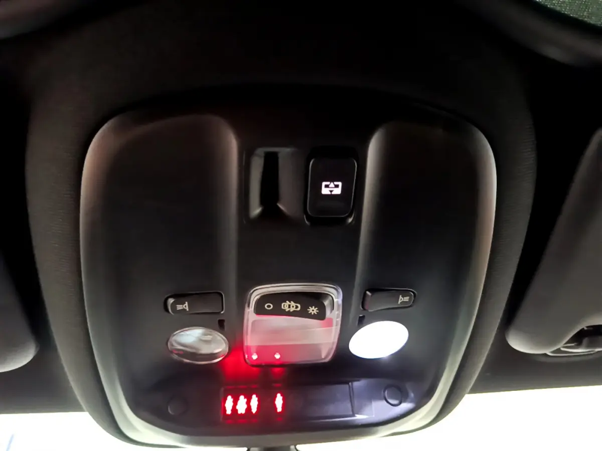 Vue en gros plan du plafonnier noir avec commandes d'éclairage et indicateurs rouges dans une Peugeot 308 gris foncé 2016.