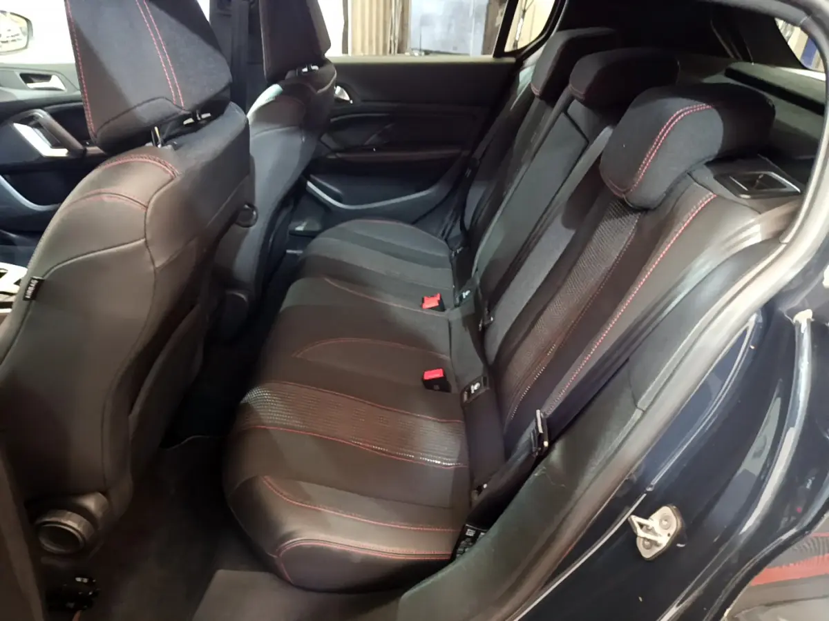 Vue intérieure côté droit sur la banquette arrière noire avec surpiqûres rouges du Peugeot 308 gris foncé.