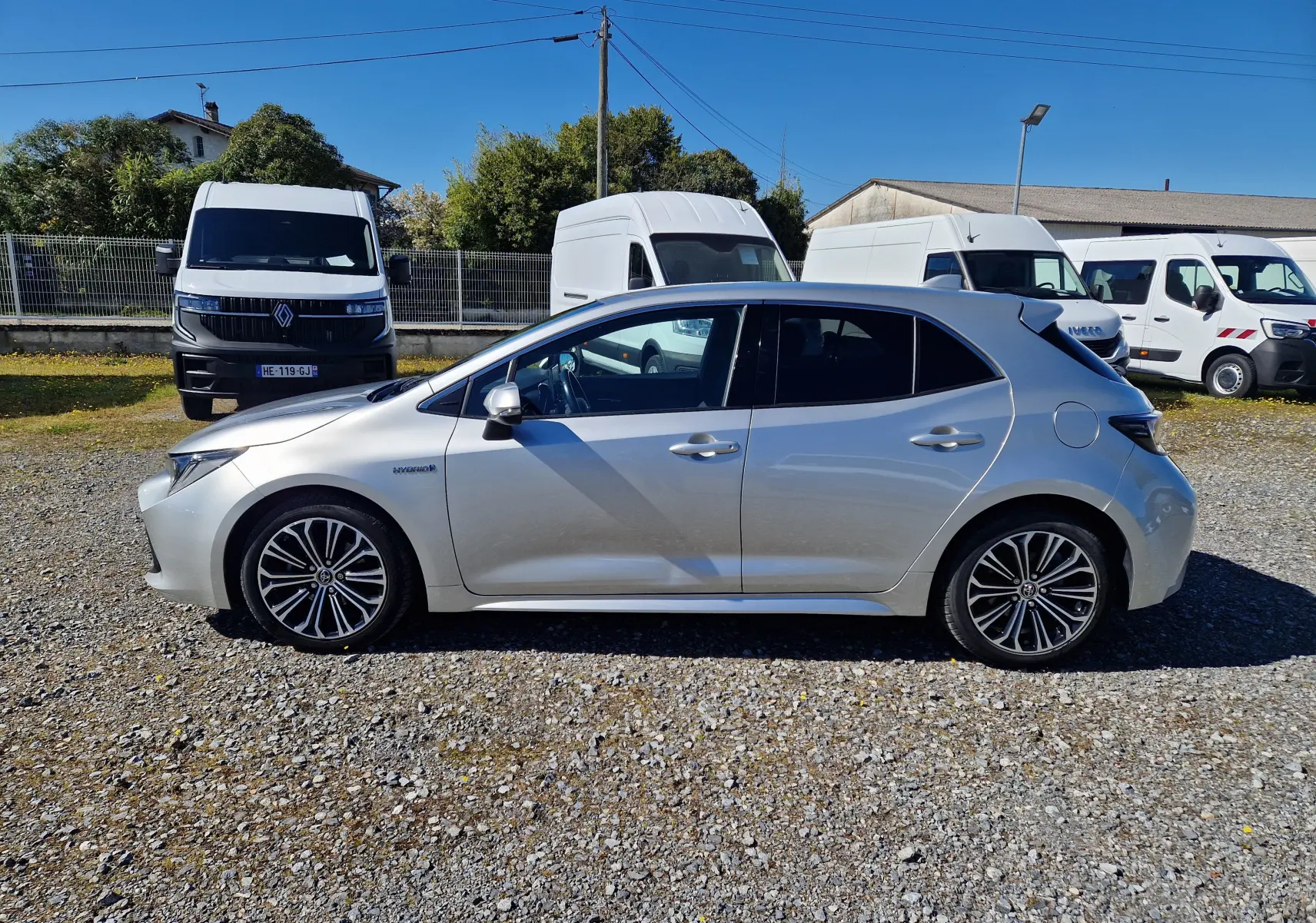 Profil droit d'une Toyota Corolla hybride gris clair métal 2019, avec jantes alliage et vitres teintées.
