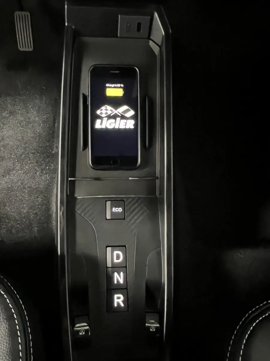Vue plongeante sur la console centrale noire de la Ligier JS50 BEV avec commandes D, N, R et bouton ECO.