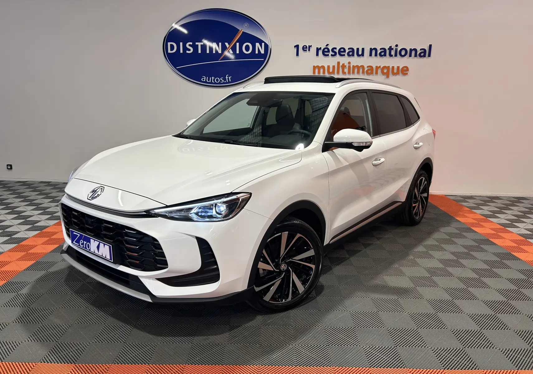 MG Motor ZS Hybrid+ 197 Luxury blanc Dover, vue 3/4 avant droit avec toit panoramique ouvrant et jantes noires bicolores.