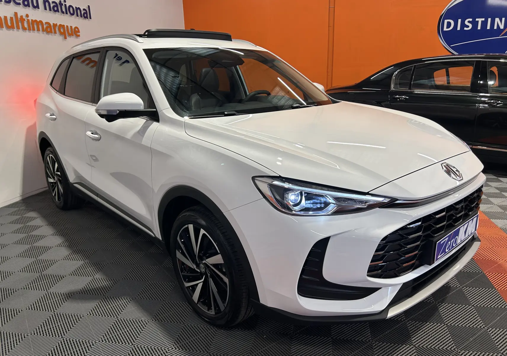 MG ZS Hybrid+ 197 Luxury blanc Dover en 3/4 avant droit, avec toit panoramique et jantes alliage noires.