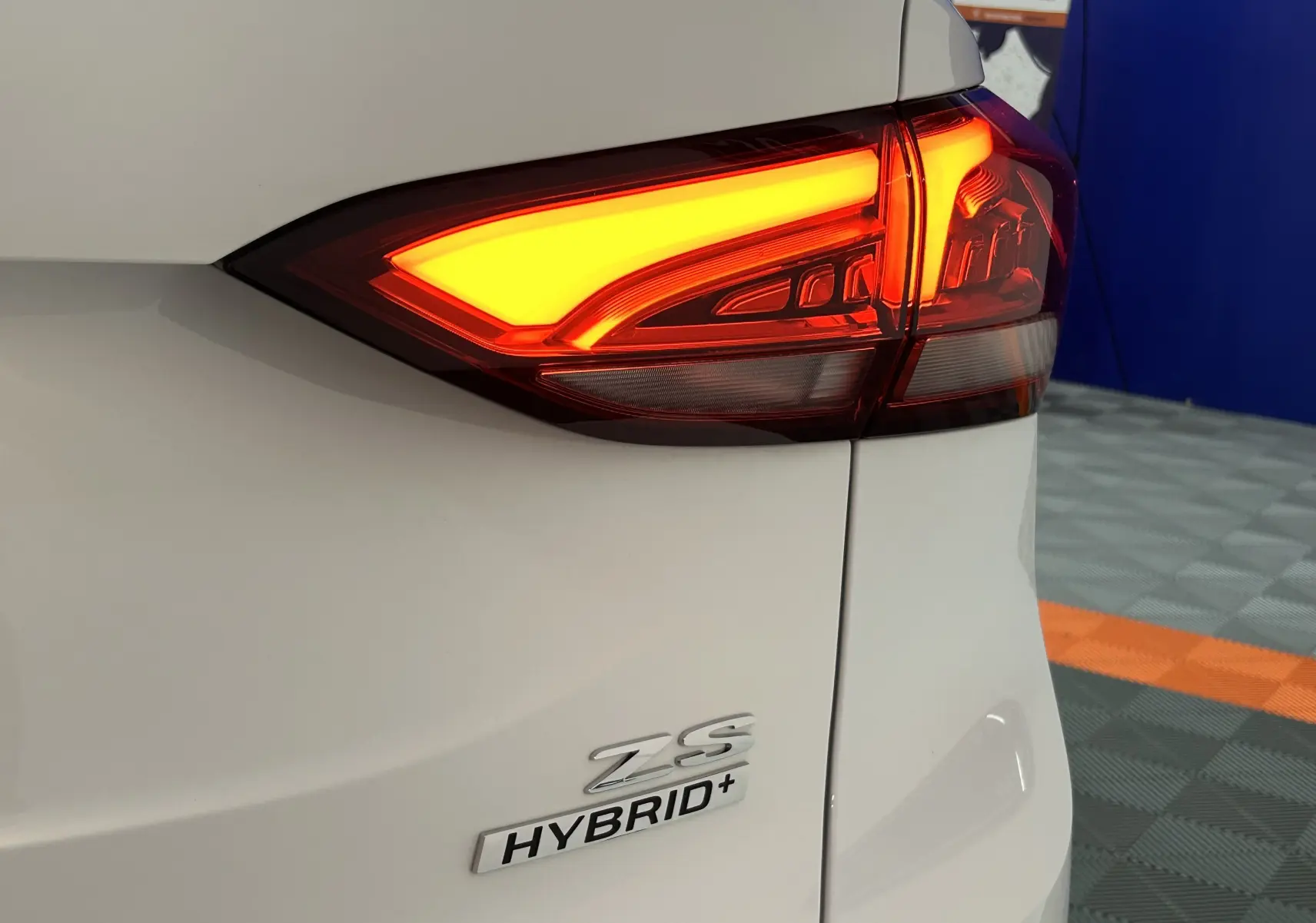 Gros plan sur le feu arrière droit allumé d’un MG ZS Hybrid+ 2026 en blanc Dover, avec logo Hybrid+ visible.
