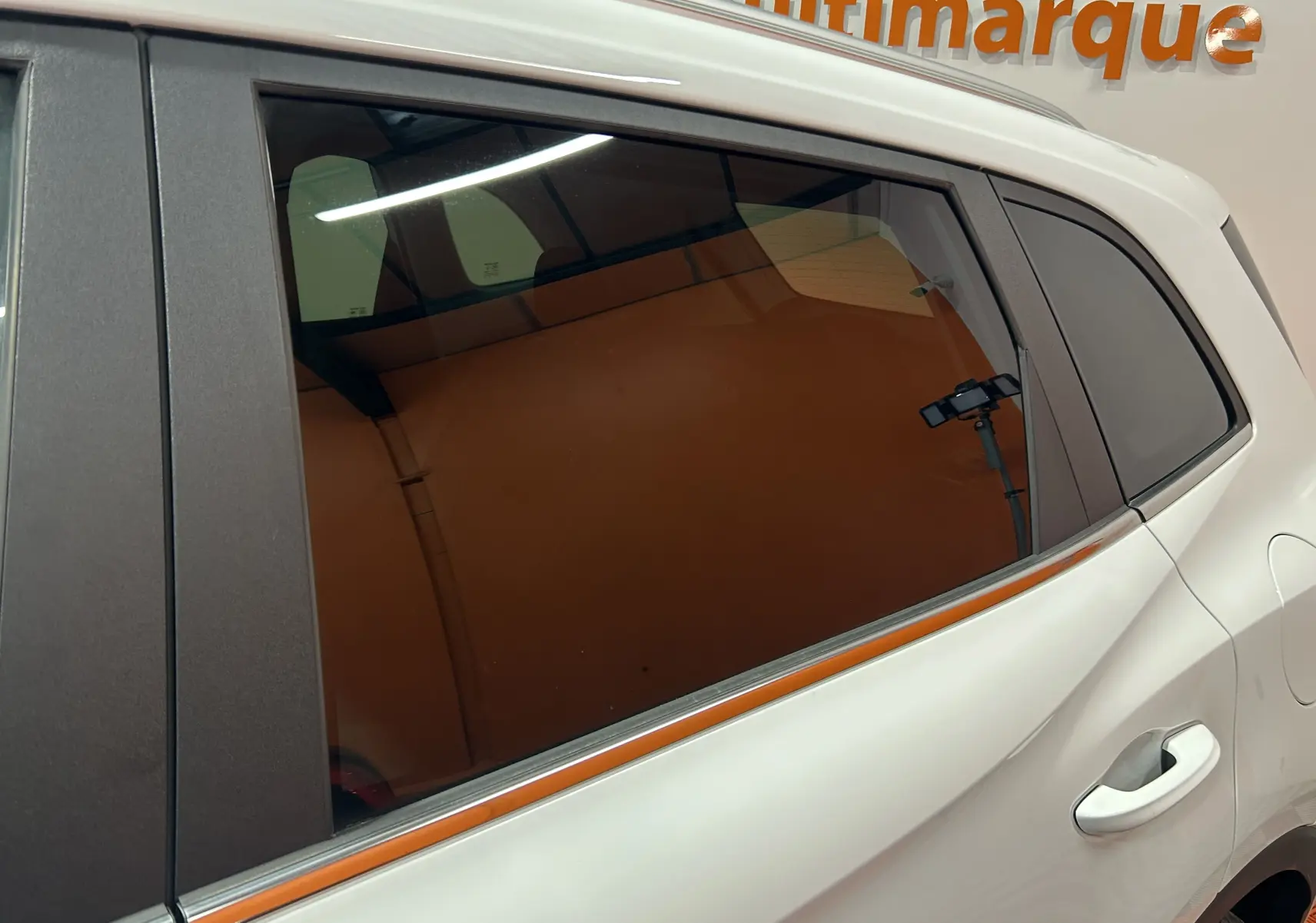 Vue latérale droite sur la porte arrière blanche du MG ZS Hybrid+ 197 Luxury avec vitre teintée et poignée intégrée.