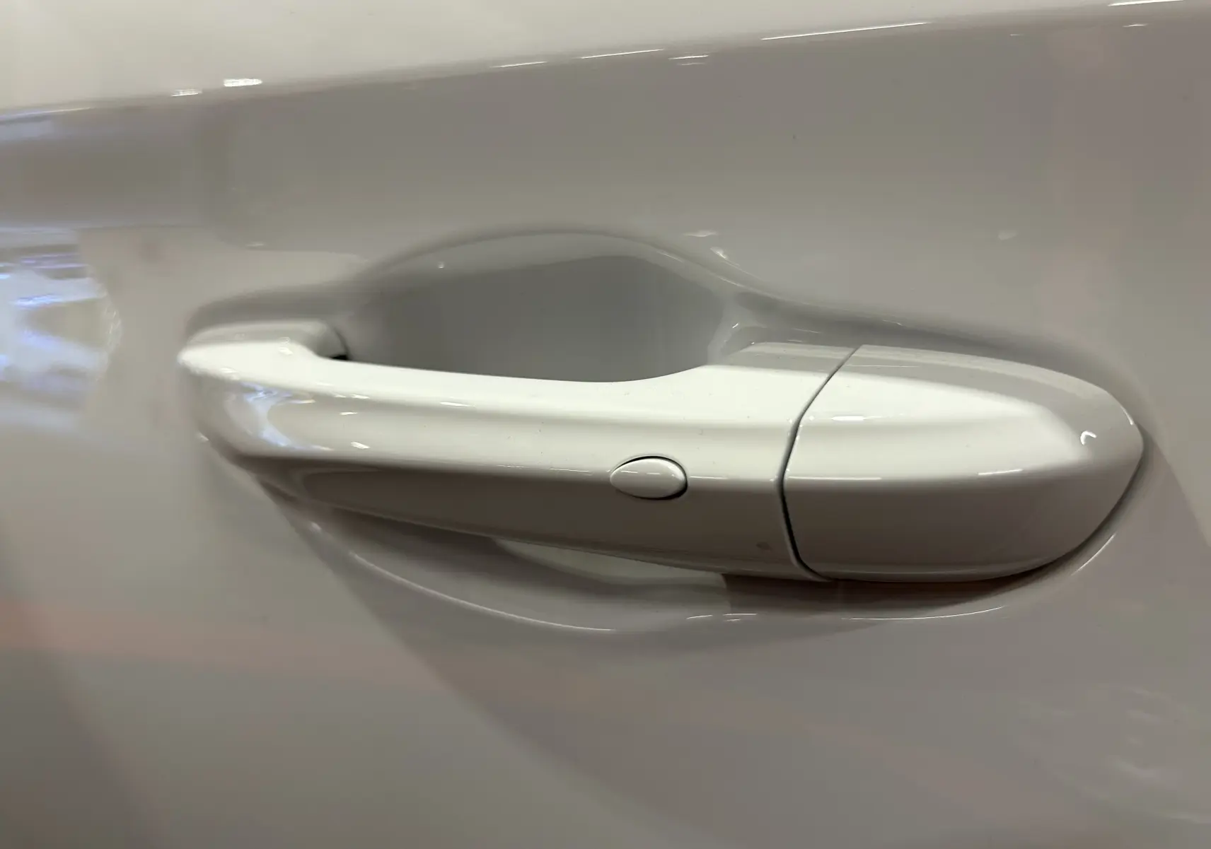 Poignée de porte blanche en gros plan sur une MG MOTOR ZS Hybrid+ 197 LUXURY 2026 couleur Dover White.