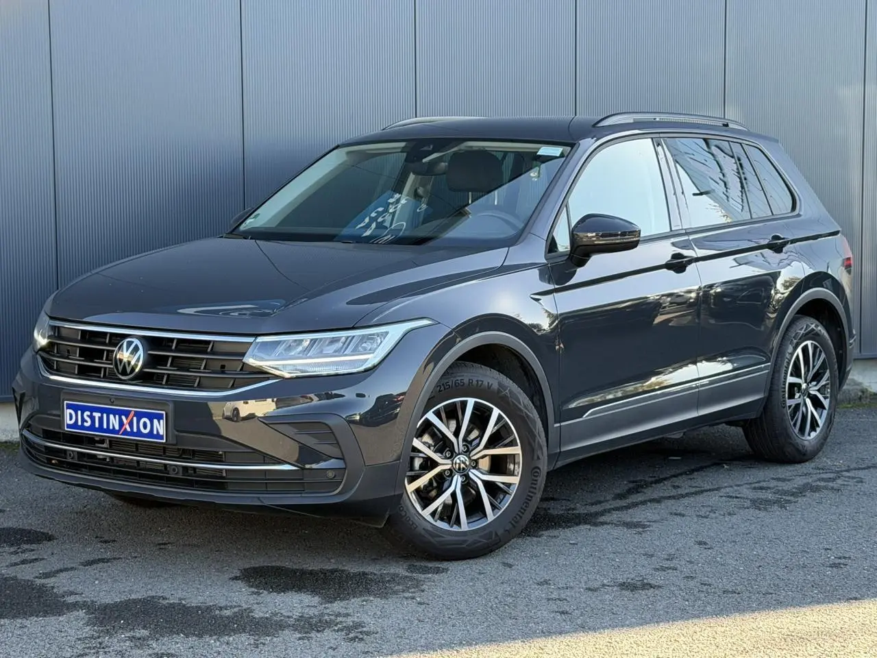 Volkswagen Tiguan 1.5 TSI 150 DSG Life gris Urano en 3/4 avant droit, jantes alliage 17 pouces visibles.