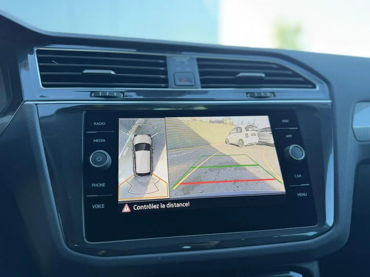 Écran tactile 8'' du Volkswagen Tiguan 2024 montrant la vue 360° et caméra de recul en marche.