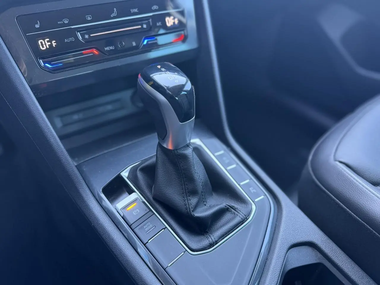 Gros plan sur la console centrale du Volkswagen Tiguan 2024, montrant le levier de vitesse automatique et les commandes de climatisation.