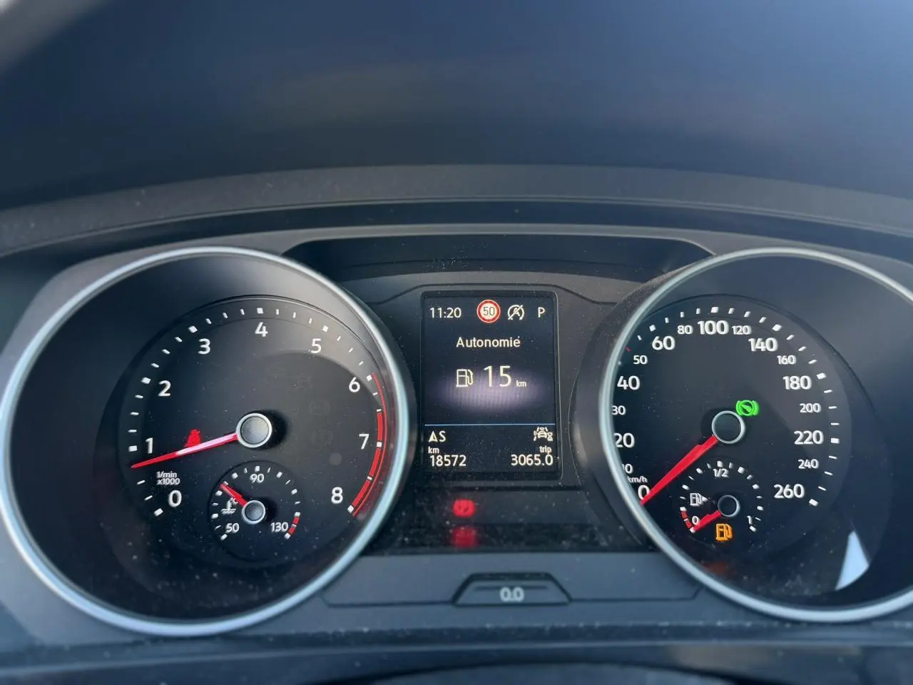 Vue rapprochée du tableau de bord du Volkswagen Tiguan gris Urano 2024, affichant l'autonomie restante de 15 km.