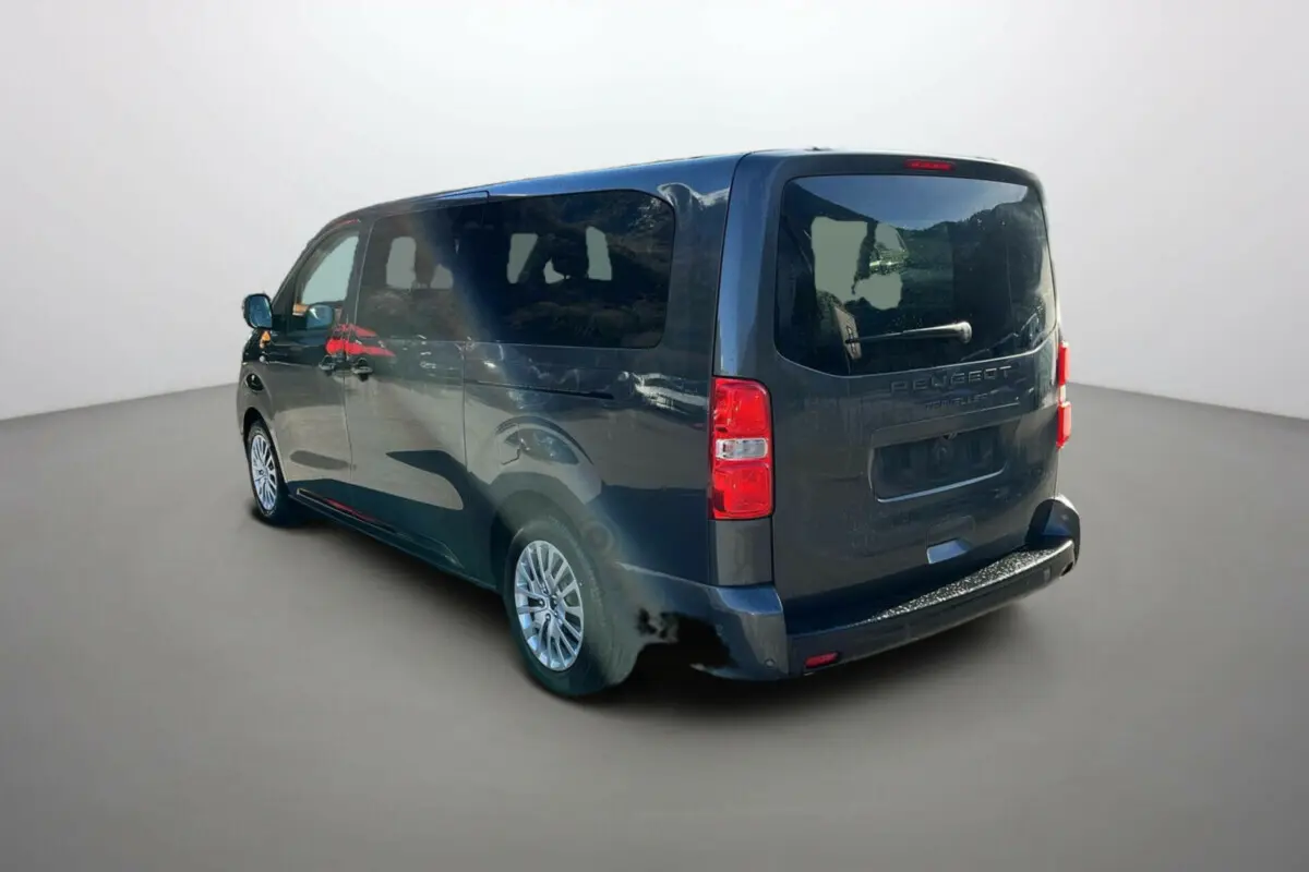 Vue 3/4 arrière droite du Peugeot Traveller gris titane avec vitres surteintées et jantes tôles 17 pouces.