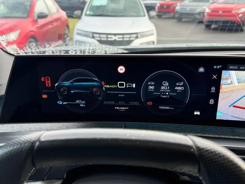 Tableau de bord numérique du Peugeot 3008 électrique bleu, affichage de l'autonomie et vitesse, vue depuis le siège conducteur.