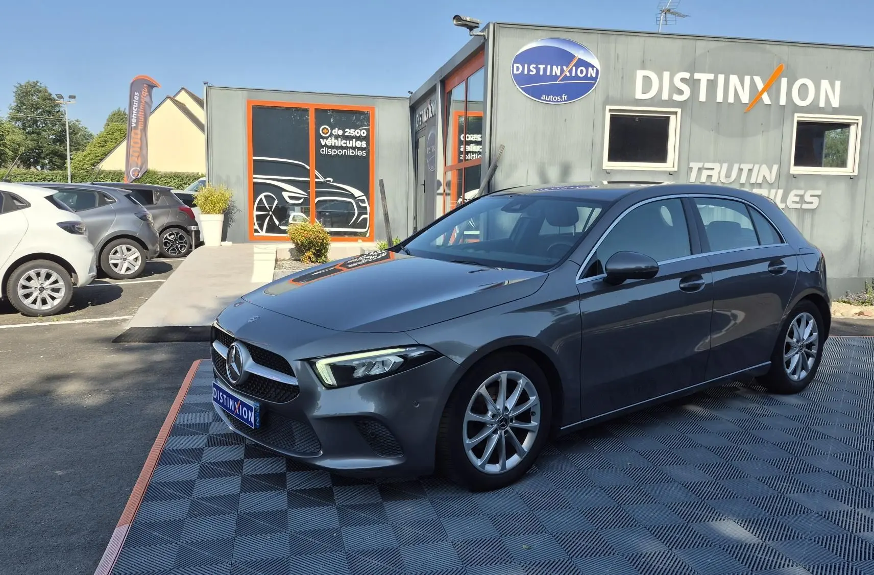 Mercedes Classe A 180d gris foncé vue 3/4 avant droit, avec jantes alliage et calandre distinctive au logo central.