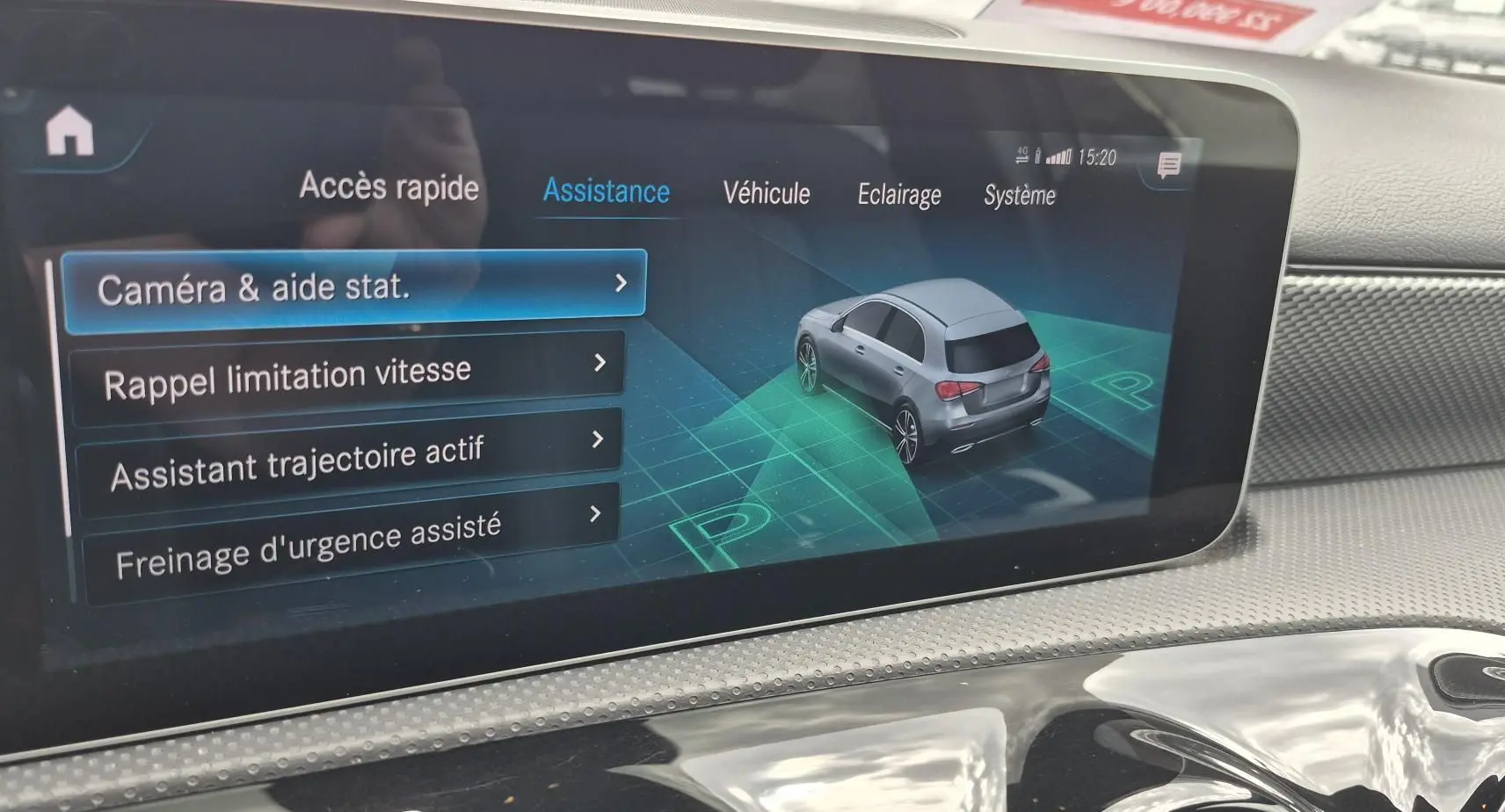 Écran intérieur montrant l'interface d'assistance de la Mercedes Classe A 180d gris foncé avec vue 3/4 arrière du véhicule.