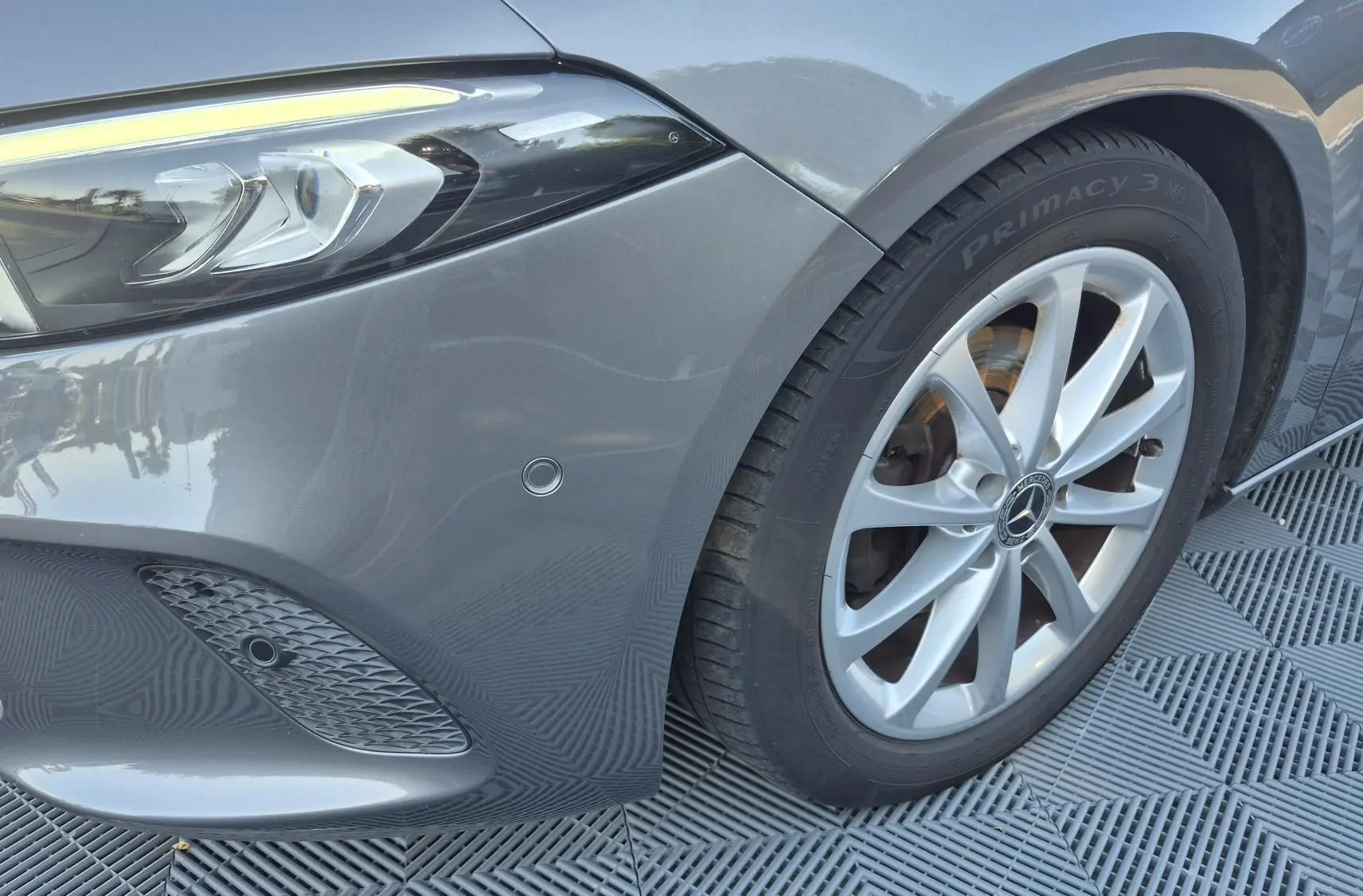 Gros plan sur l'avant droit gris foncé d'une Mercedes Classe A 180d 2020, avec phare LED et jante alliage 17 pouces.