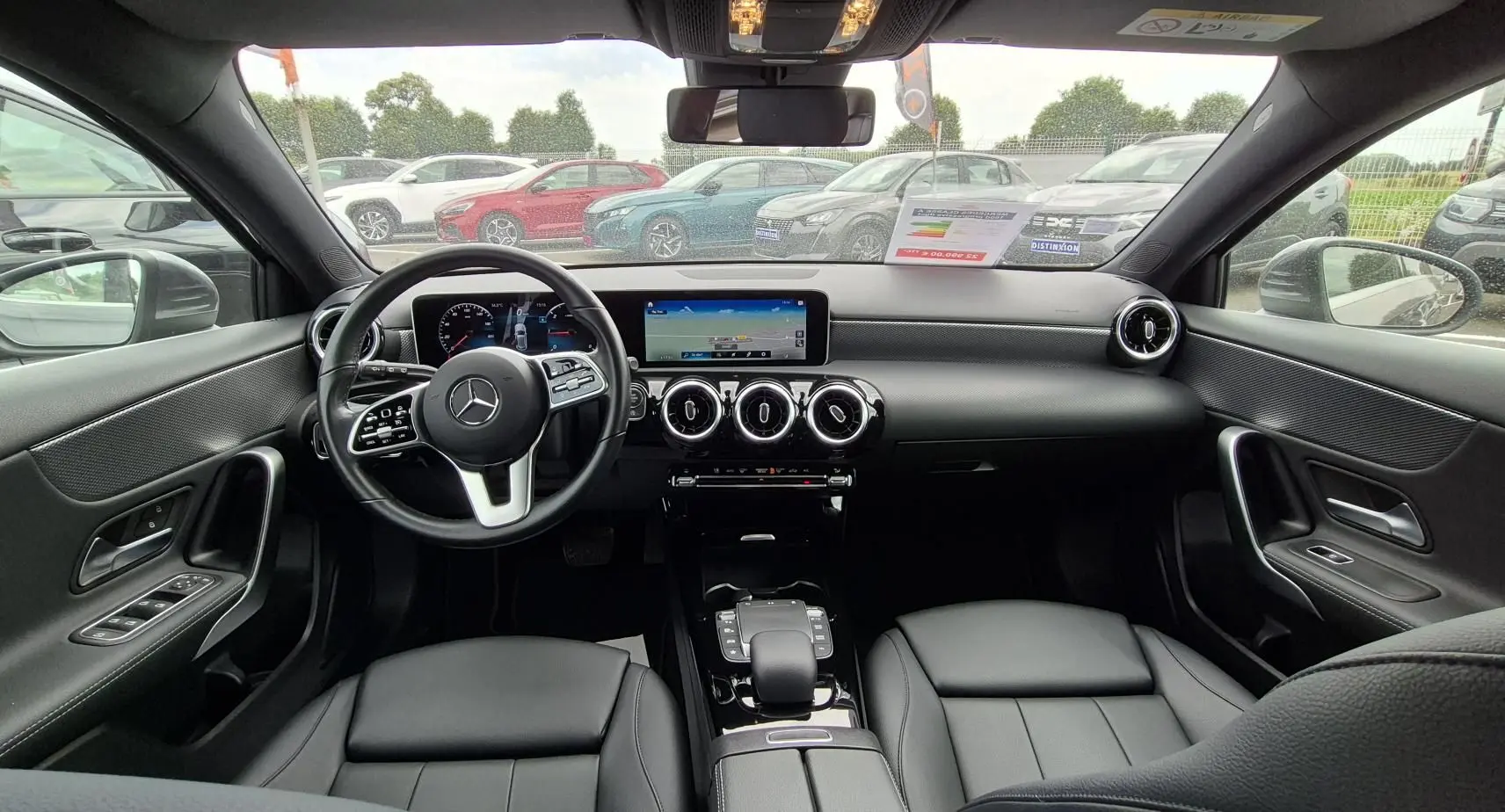 Vue intérieure avant de la Mercedes Classe A 180d 2020, avec tableau de bord moderne et sièges cuir noir.
