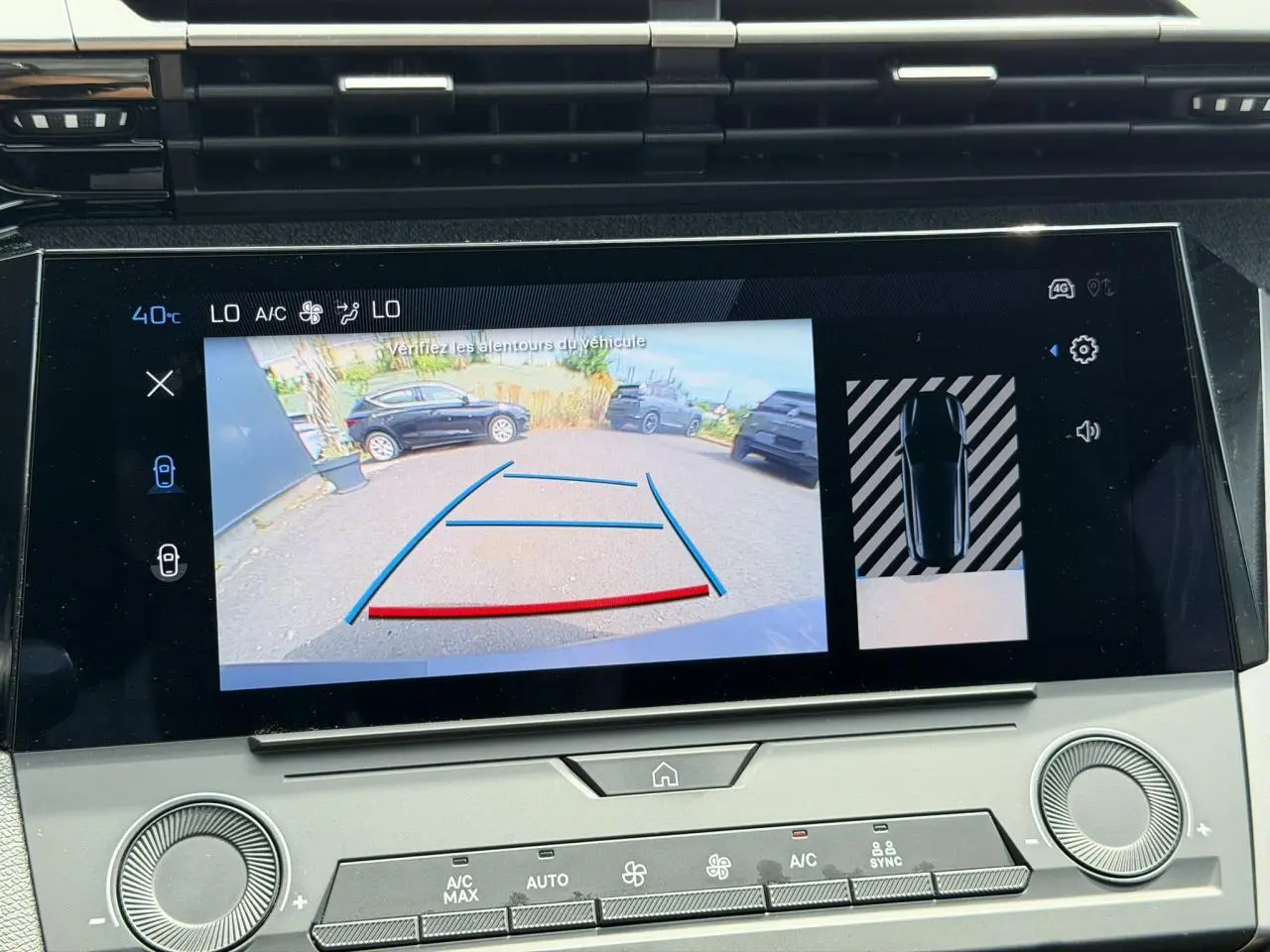 Écran tactile central montrant la caméra de recul et l’aide au stationnement du Peugeot 308 SW gris Selenium, vue intérieure.