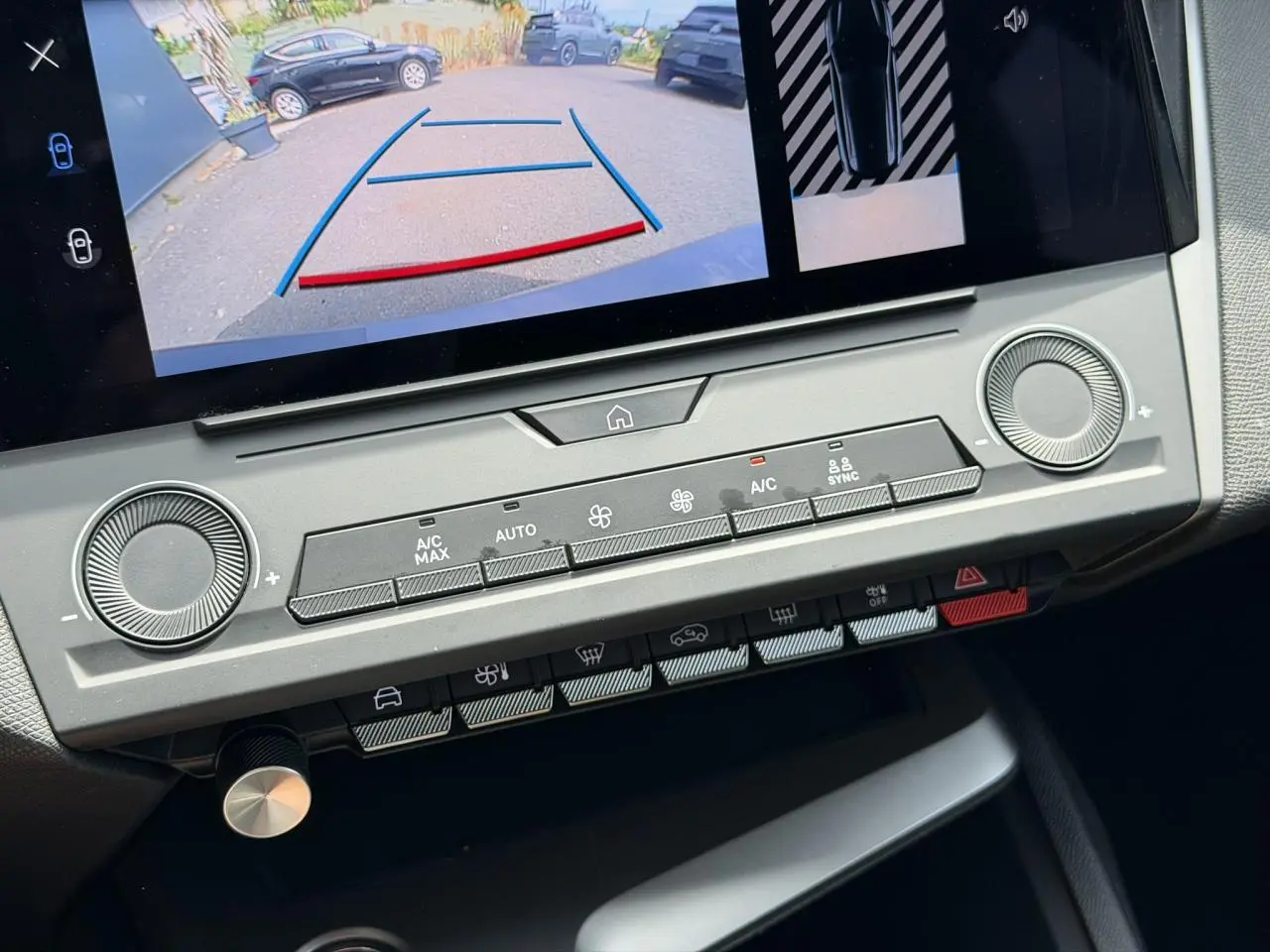 Détail de la console centrale du Peugeot 308 SW 2025 avec écran tactile affichant la caméra de recul et commandes climatisation grises.