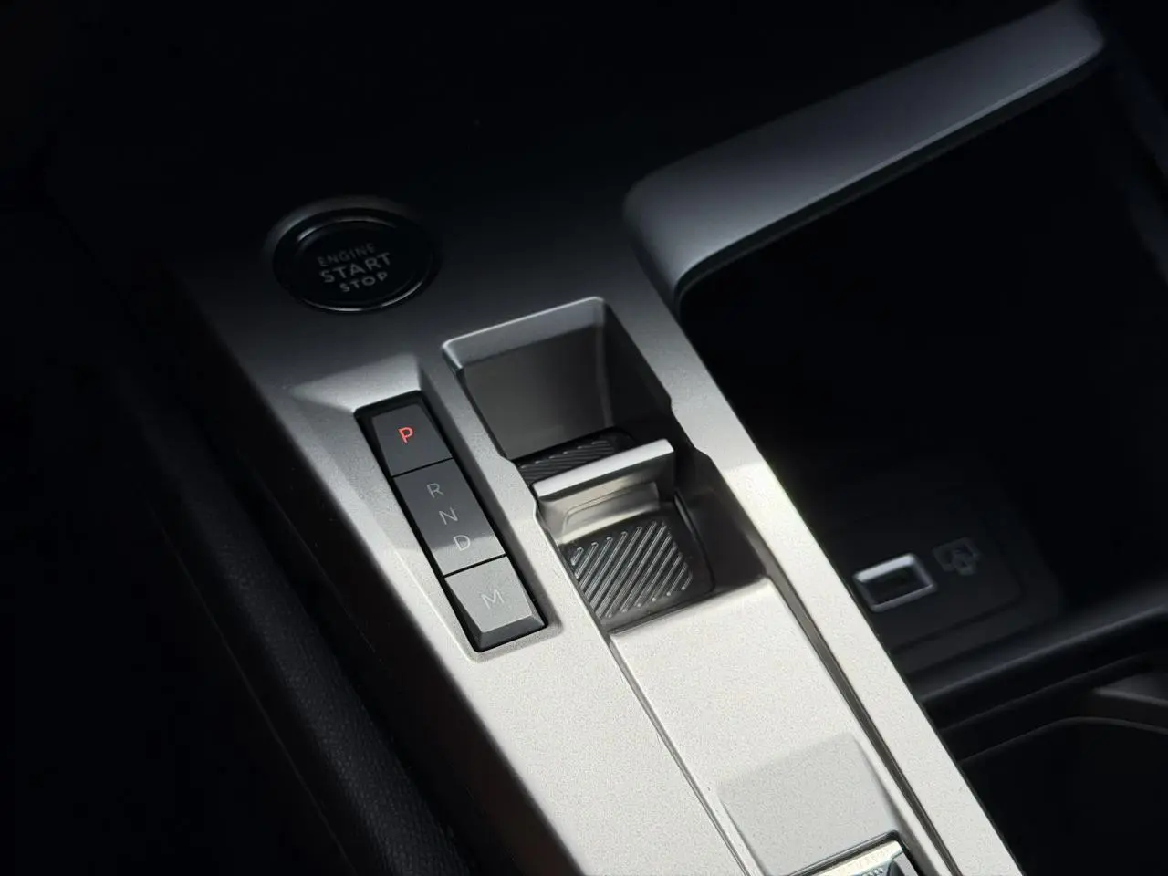 Gros plan sur la console centrale argentée avec sélecteur de boîte automatique et bouton start/stop dans une Peugeot 308 SW 2025.