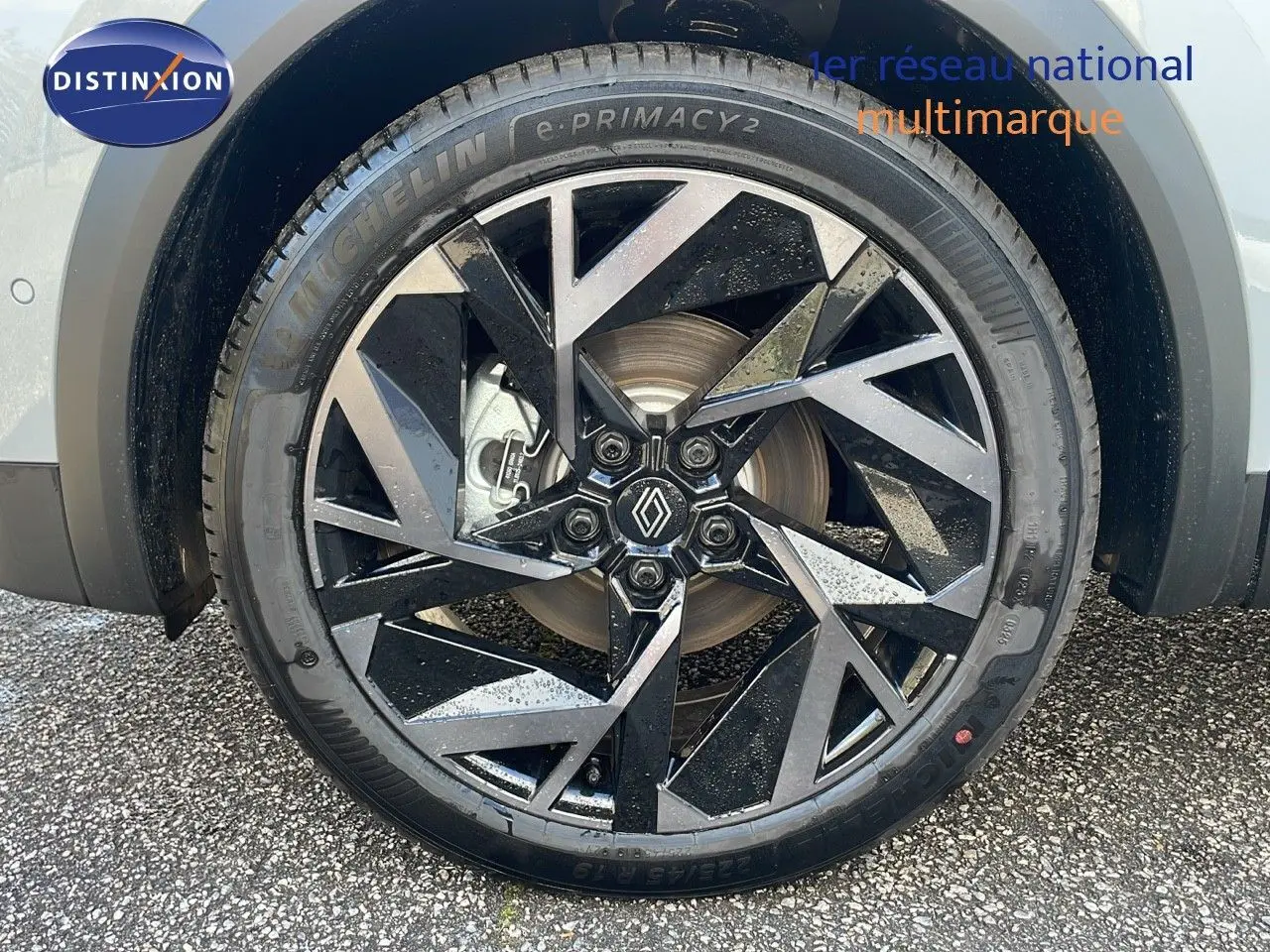 Gros plan sur la roue avant gauche du Renault Captur gris Rafale avec jante diamantée noire et argentée.