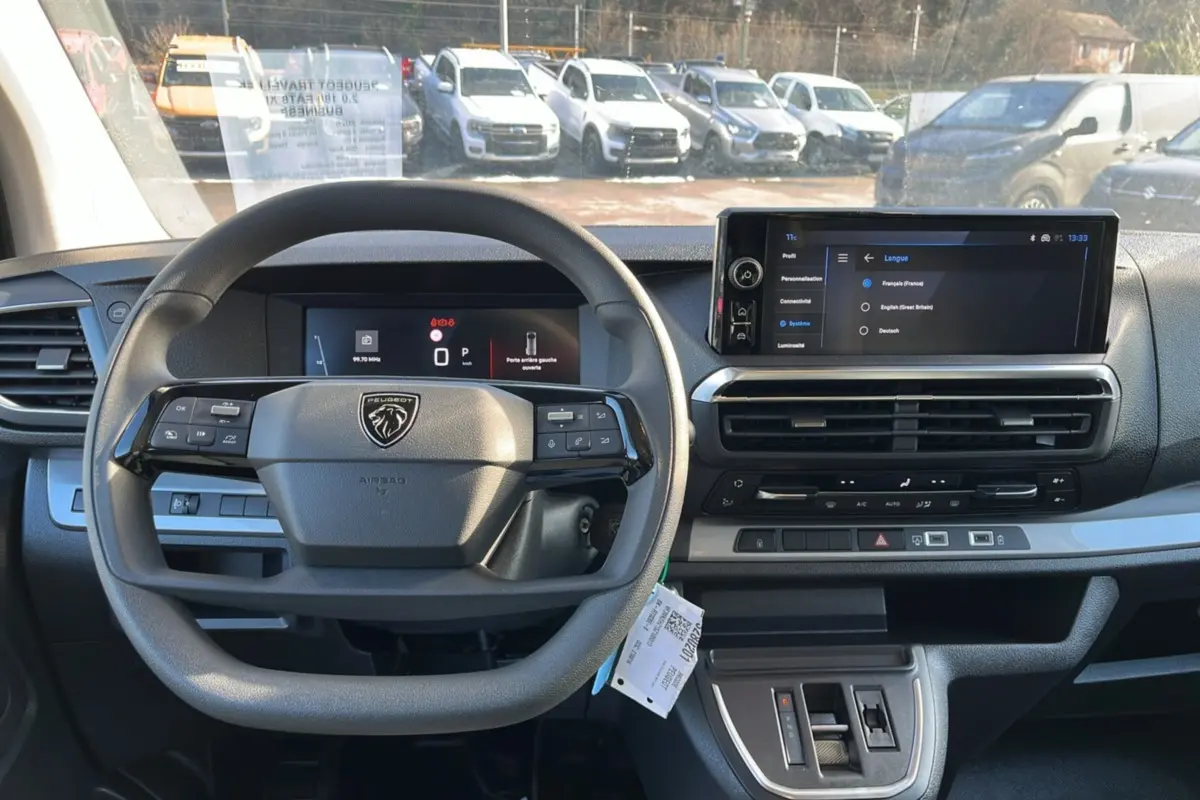 Vue intérieure frontale du Peugeot Traveller gris acier 2025, avec volant multifonctions et écran tactile central.