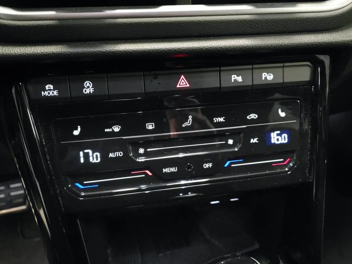 Vue rapprochée du panneau de commande de climatisation automatique bi-zone noir brillant du Volkswagen T-Roc gris 2025 R-Line.