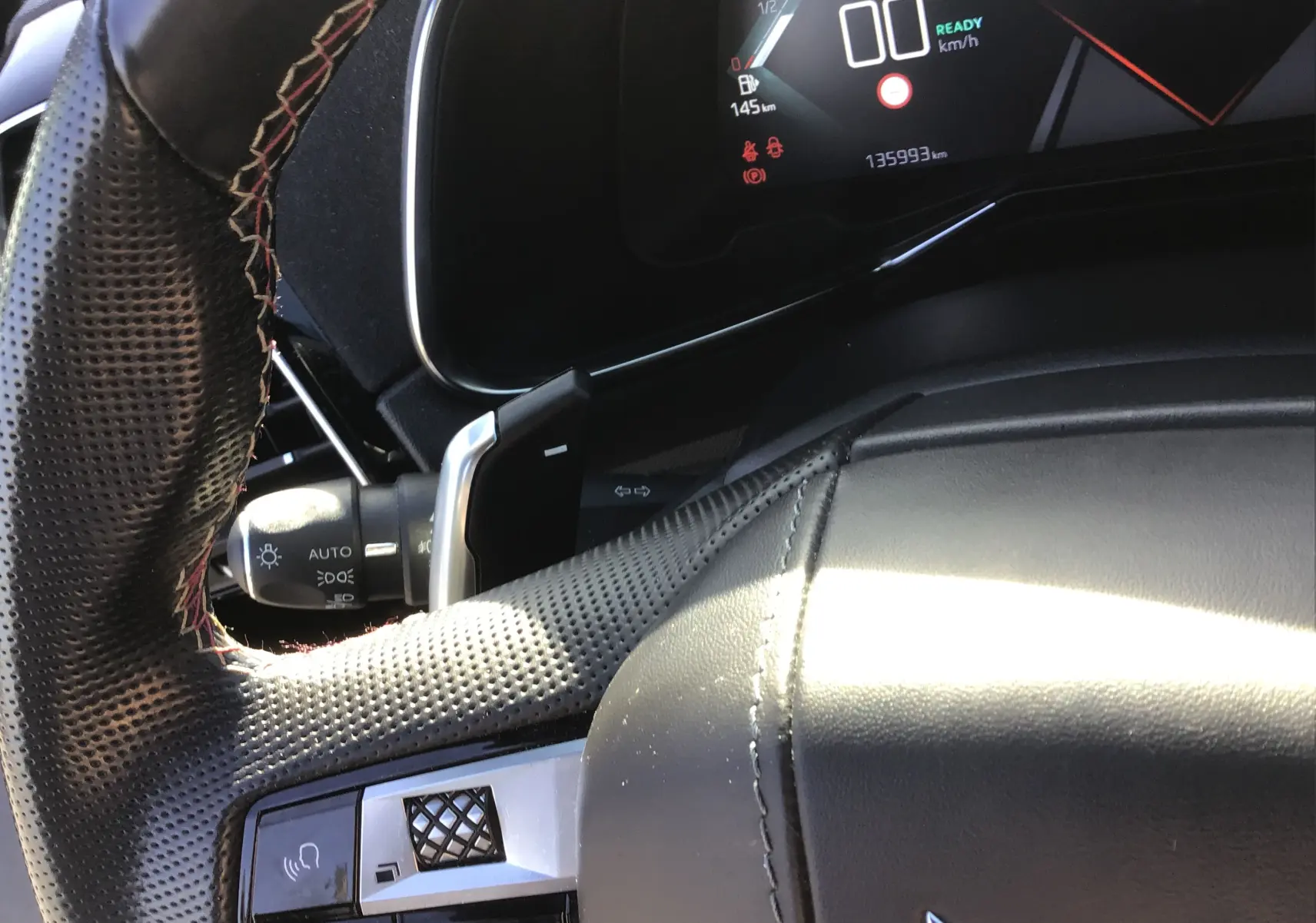 Gros plan sur le volant en cuir perforé et le tableau de bord digital du DS7 Crossback noir, version hybride 2023.