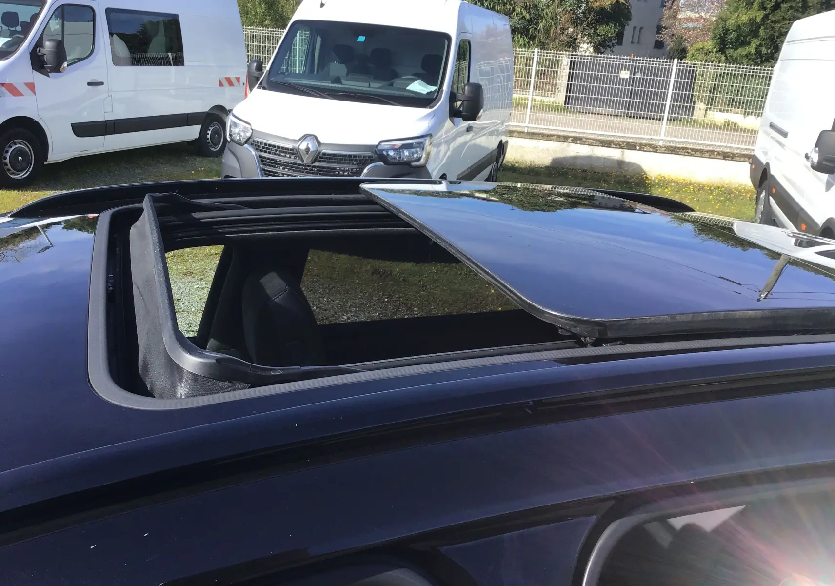 Toit ouvrant panoramique ouvert sur le dessus d'un DS7 Crossback noir, vue partielle en extérieur.