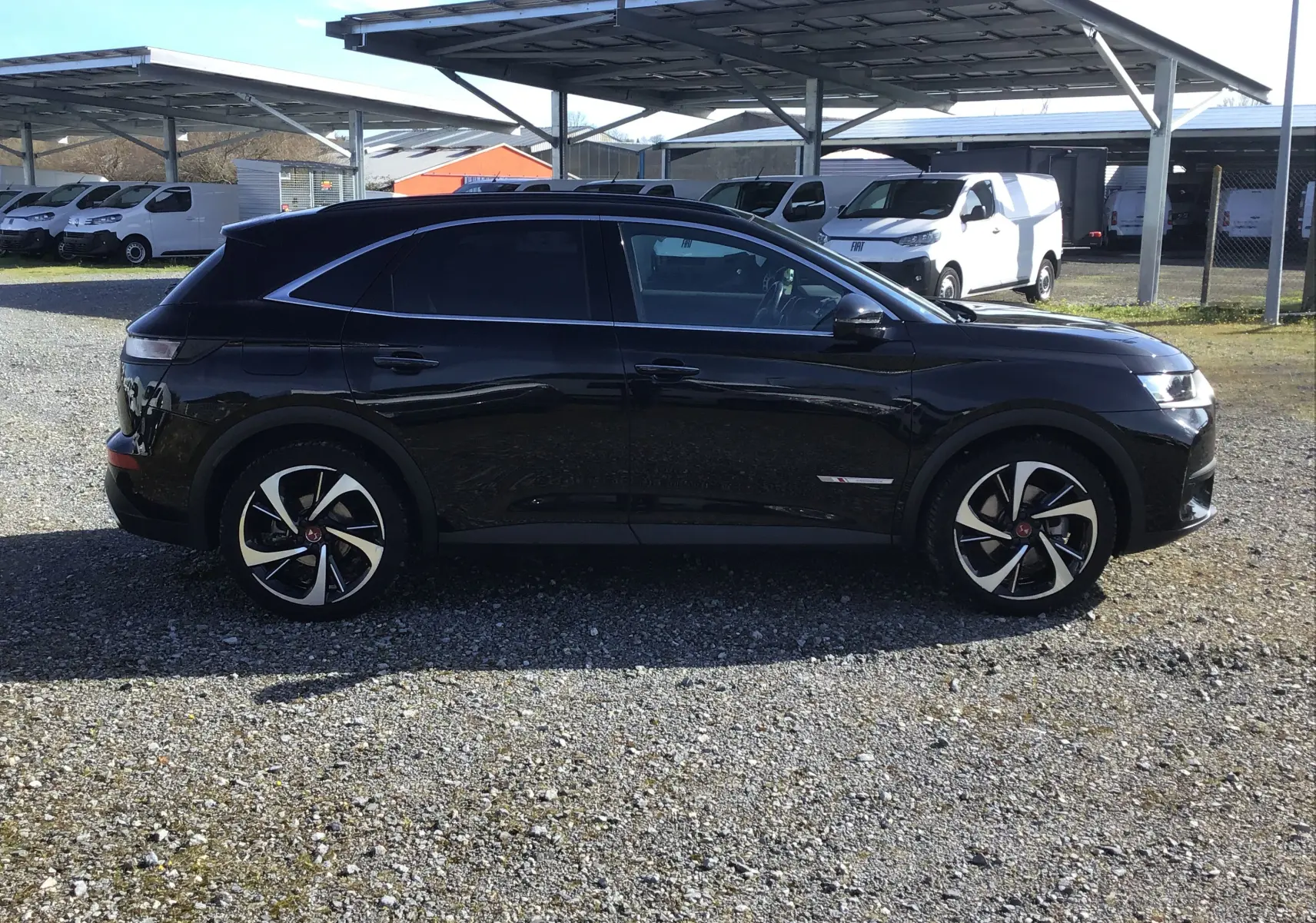 Vue de profil côté gauche du DS7 Crossback noir 2023, soulignant ses jantes distinctives et sa silhouette élégante.