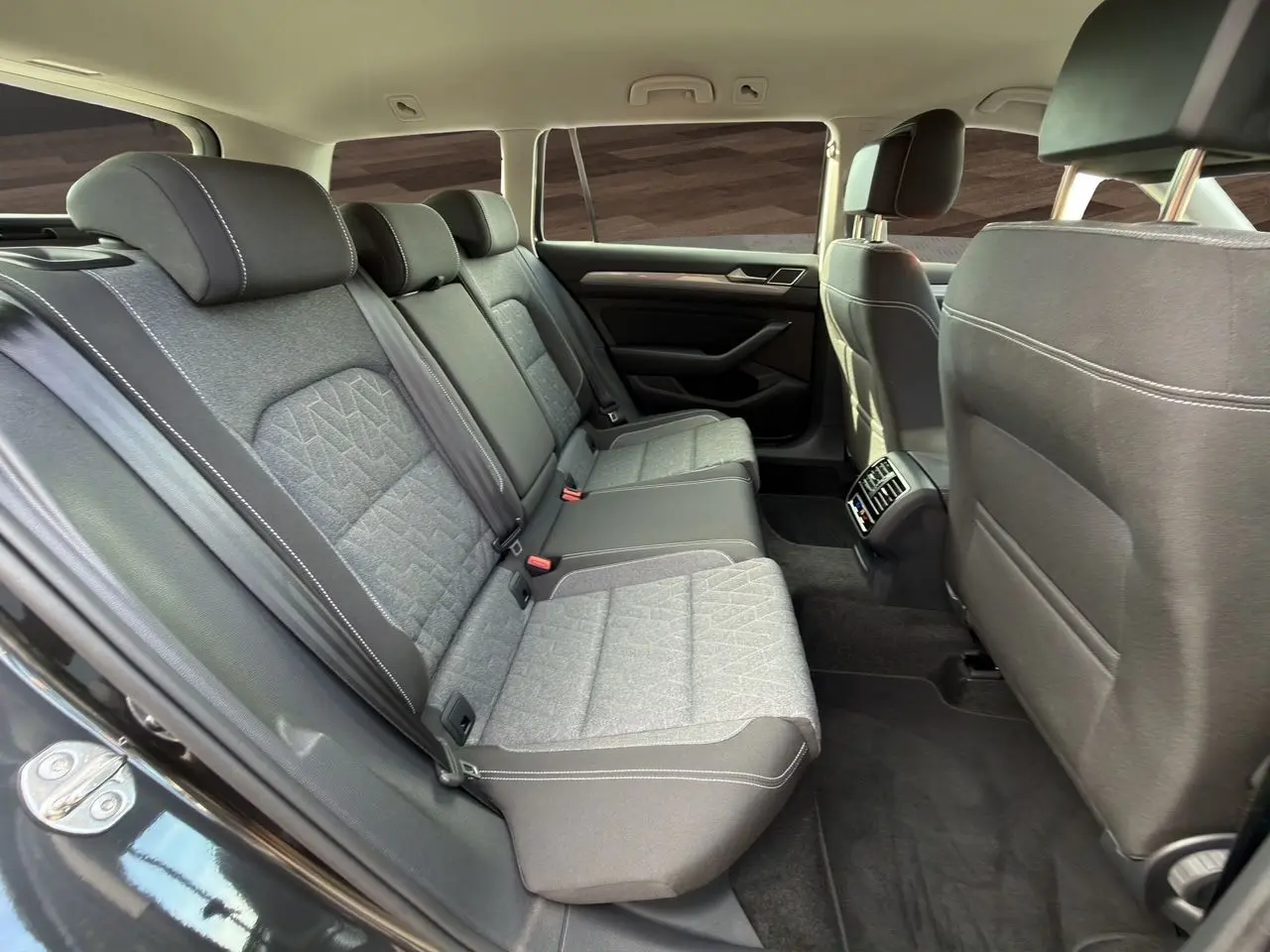 Vue intérieure côté gauche des sièges arrière gris tissu avec surpiqûres blanches de la Volkswagen Passat SW 2022.