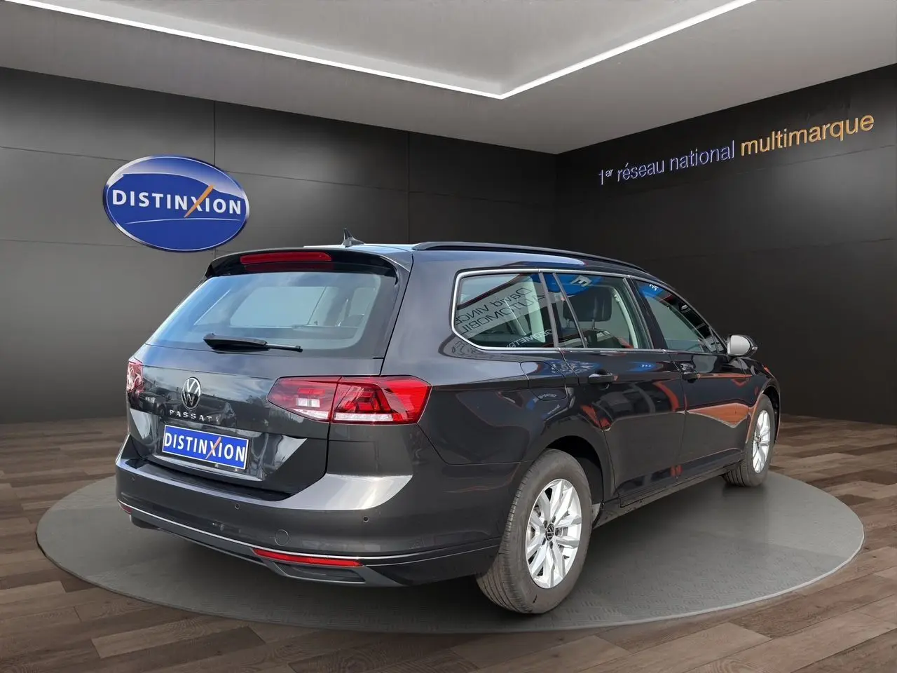 Volkswagen Passat SW gris manganese vue 3/4 arrière droit, avec jantes alliage et caméra de recul visible.