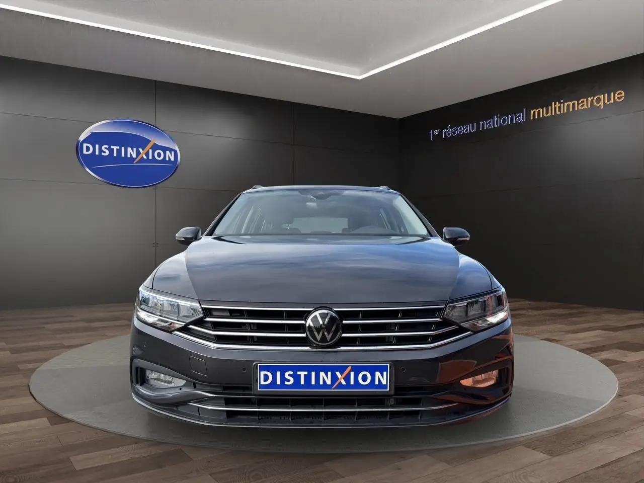 Vue frontale d'une Volkswagen Passat SW gris manganèse 2022 avec calandre chromée et logo VW visible.