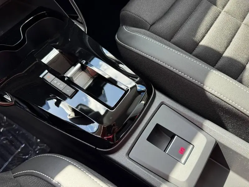 Gros plan sur la console centrale noire brillante et le siège gris du Citroën C3 Aircross 1.2 Hybride 2026.