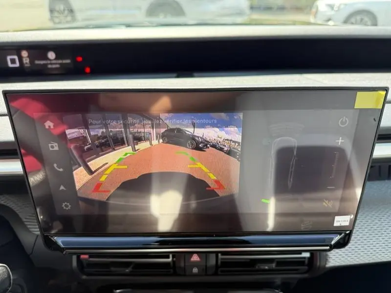 Écran tactile intérieur montrant la caméra de recul d'un Citroën C3 Aircross Vert Montana avec repères colorés.