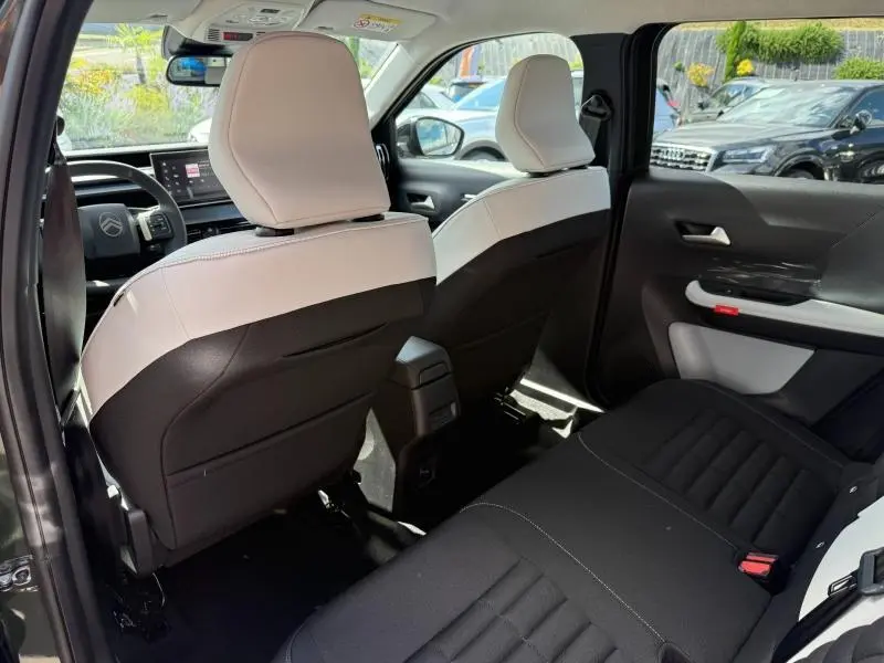 Vue arrière intérieure du Citroën C3 Aircross 2026, sièges avant blanc opale et banquette arrière noire.
