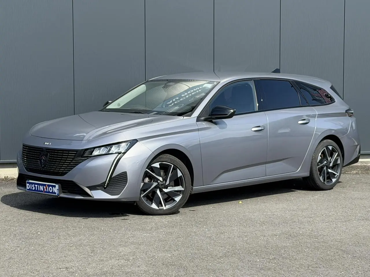 Peugeot 308 SW gris Artense en 3/4 avant droit, avec jantes alliage 17'' et vitres surteintées.