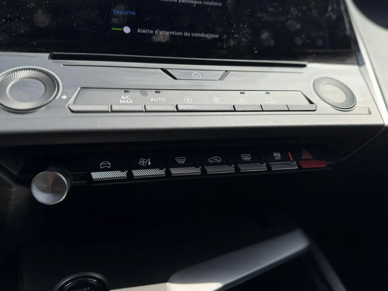 Vue rapprochée du tableau de bord de la Peugeot 308 SW 2025, mettant en valeur les commandes de climatisation et les boutons fonctionnels.