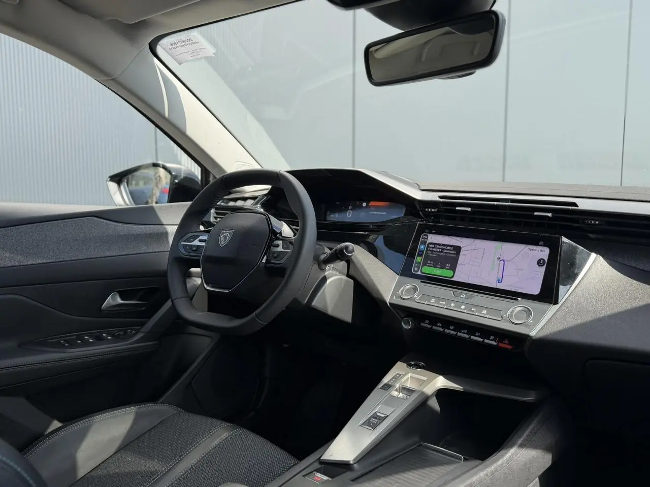 Intérieur avant droit du Peugeot 308 SW 2025, tableau de bord moderne avec écran tactile et volant cuir noir.