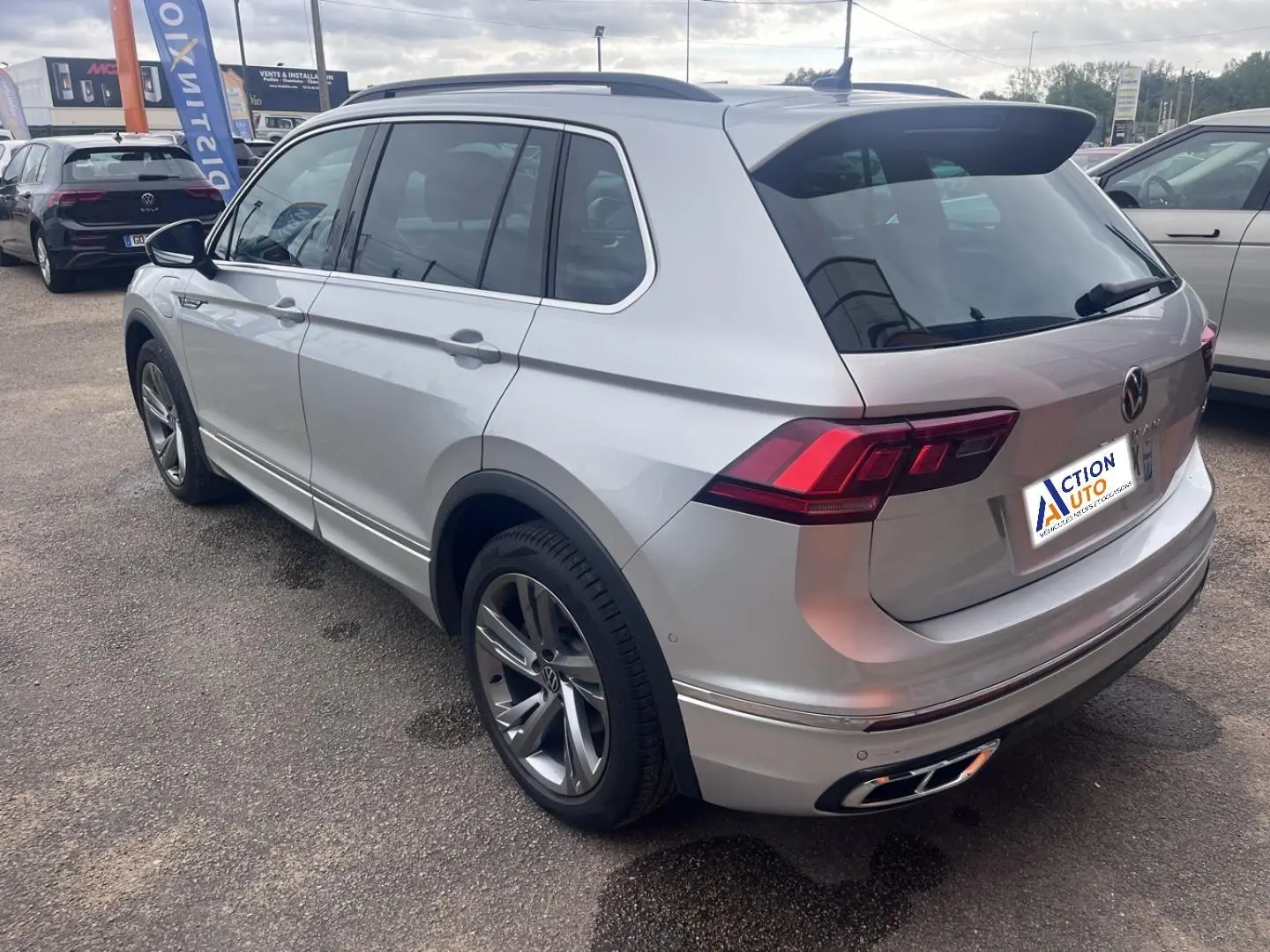 Volkswagen Tiguan 1.4 eHybrid gris dauphin métallisé vu 3/4 arrière droit avec jantes alu et barres de toit.