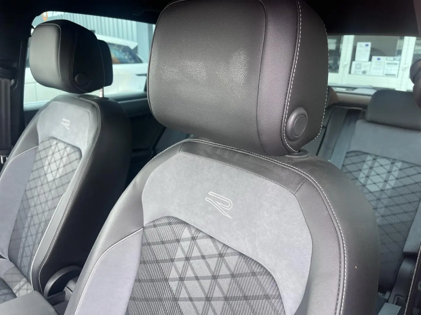 Gros plan sur les sièges avant en cuir et tissu gris avec logo R brodé, intérieur du Volkswagen Tiguan 2023.