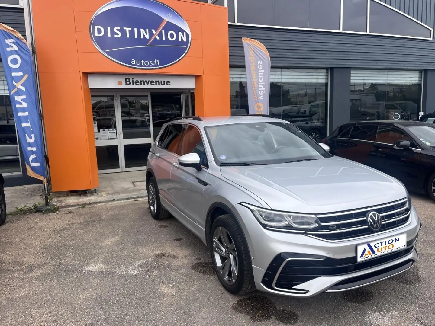 Volkswagen Tiguan 1.4 eHybrid gris dauphin métallisé, vue 3/4 avant droit devant un garage Distinxion.