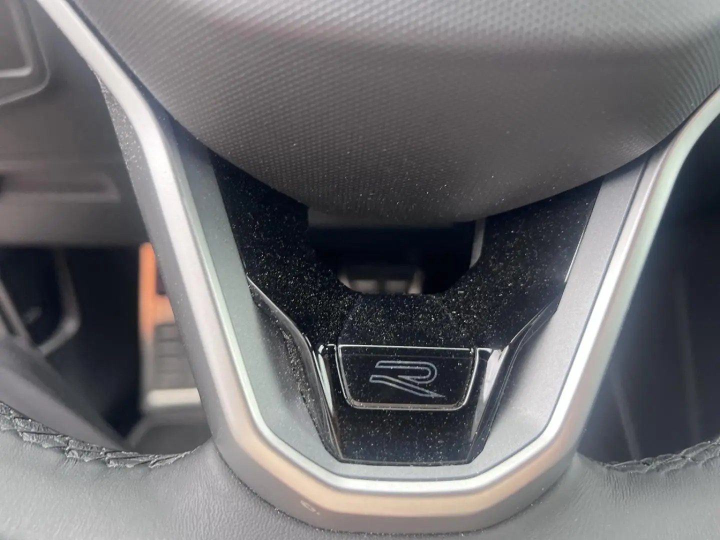 Gros plan sur le volant cuir noir avec logo R du Volkswagen Tiguan 1.4 eHybrid 245ch R-Line 2023.