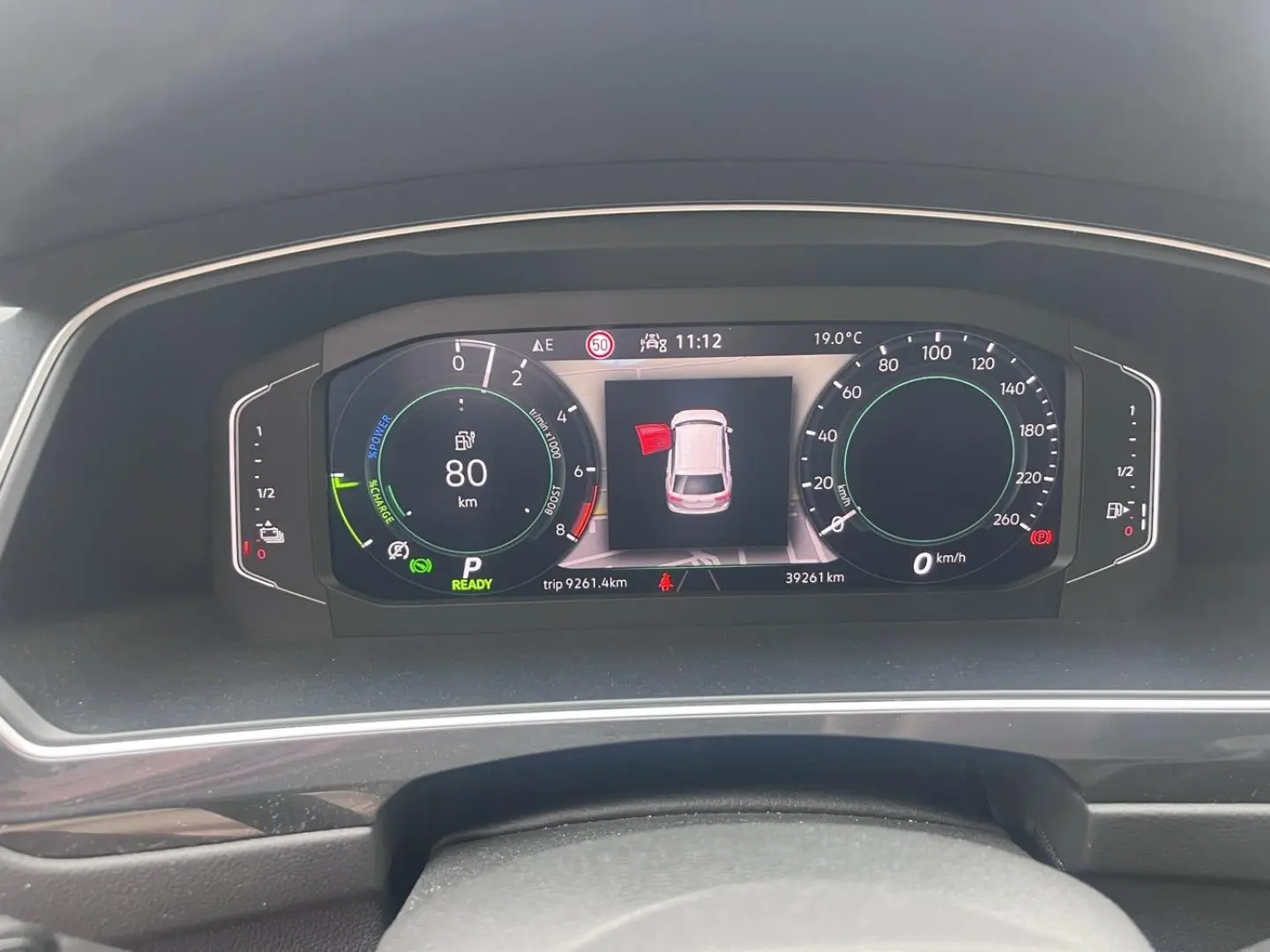 Tableau de bord numérique du Volkswagen Tiguan 1.4 eHybrid 2023 affichant vitesse, autonomie et alertes.
