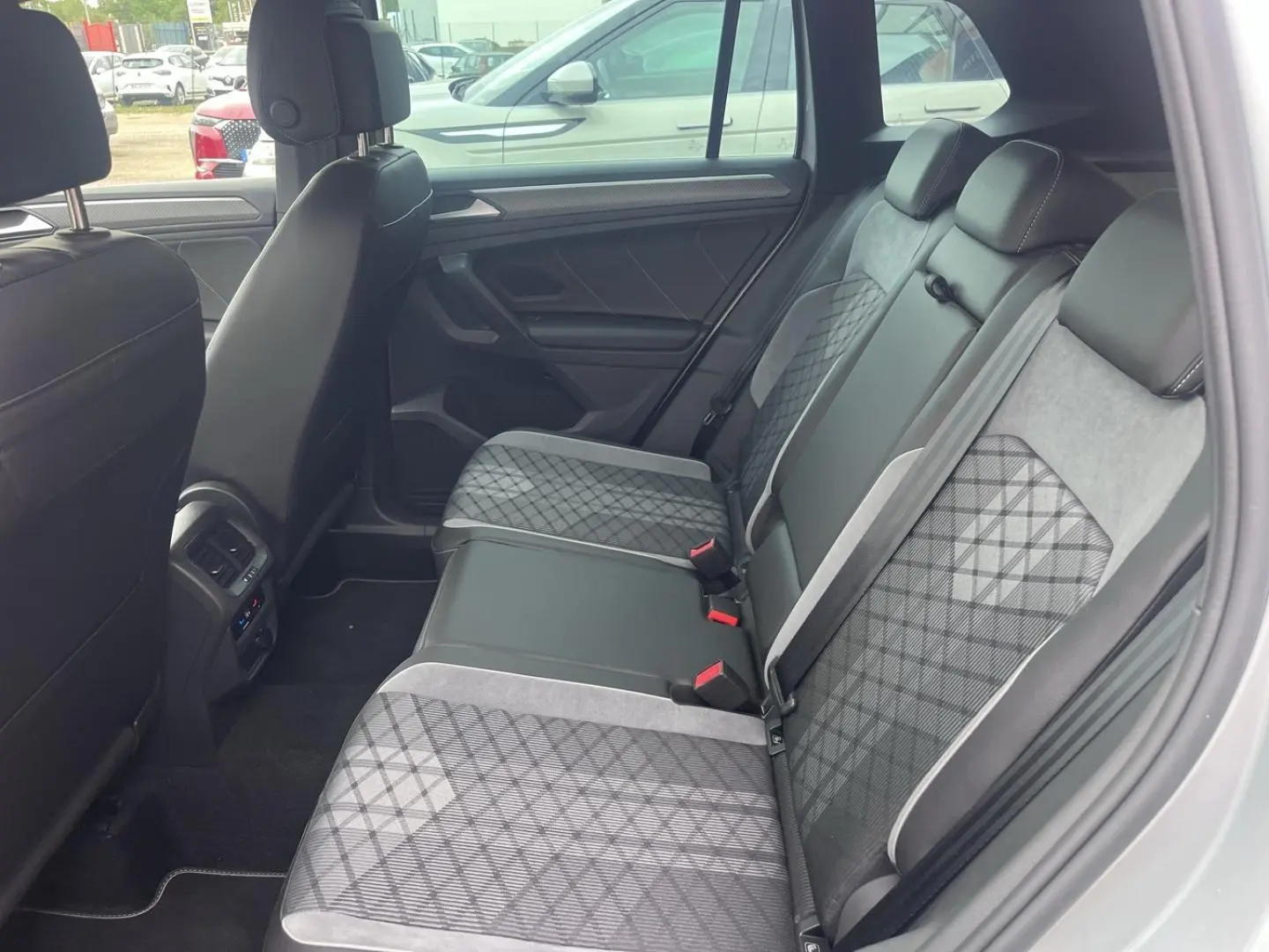 Vue latérale droite de l’intérieur arrière du Volkswagen Tiguan 2023 avec sièges tissu et cuir gris à motifs géométriques.