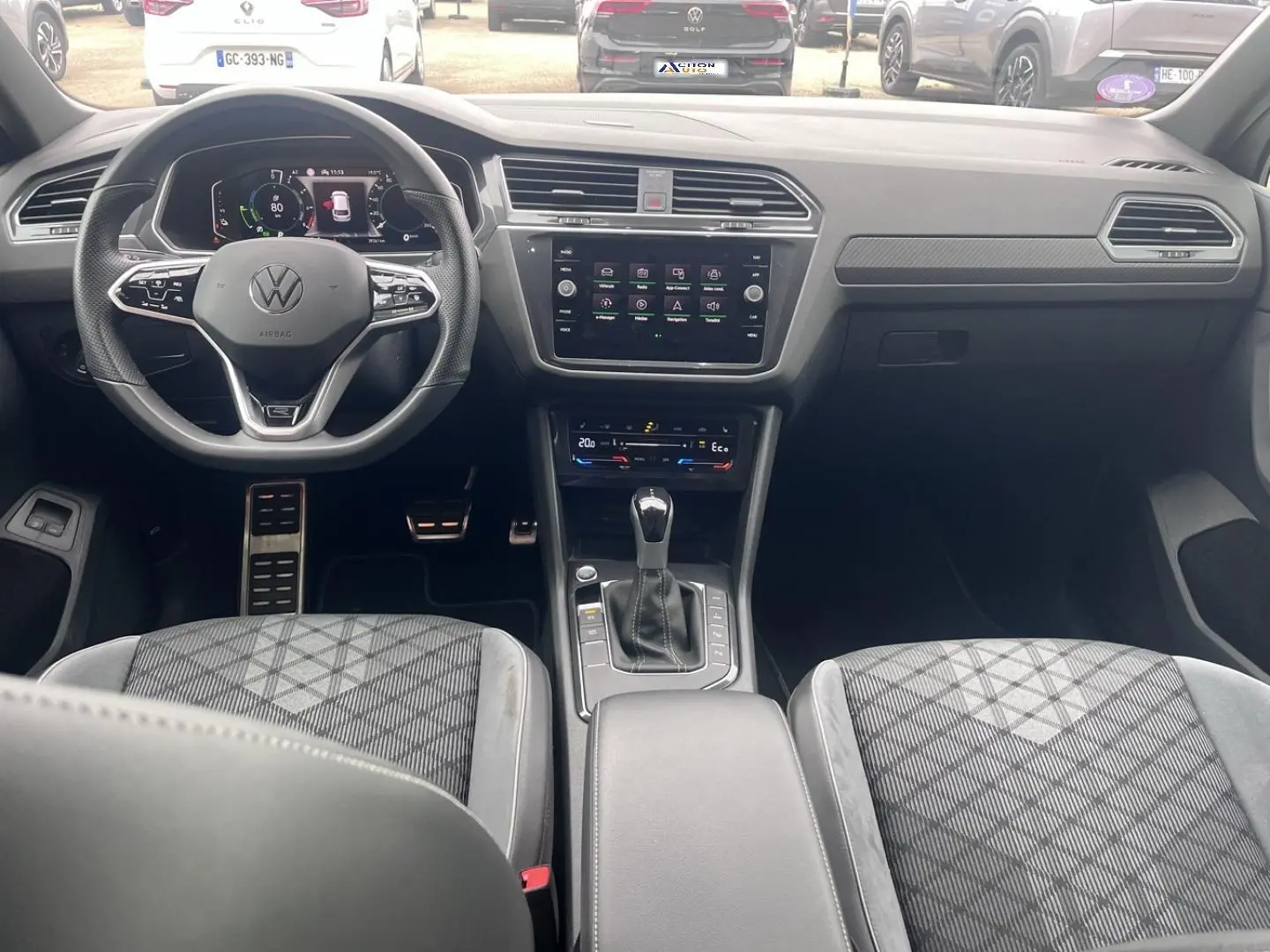 Vue intérieure avant du Volkswagen Tiguan gris Dauphin, avec volant multifonction, écran tactile central et sièges sport gris.
