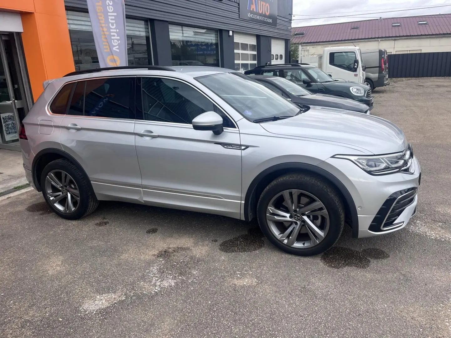 Volkswagen Tiguan 1.4 eHybrid gris dauphin métallisé vu de profil côté gauche, jantes alu et vitres surteintées.