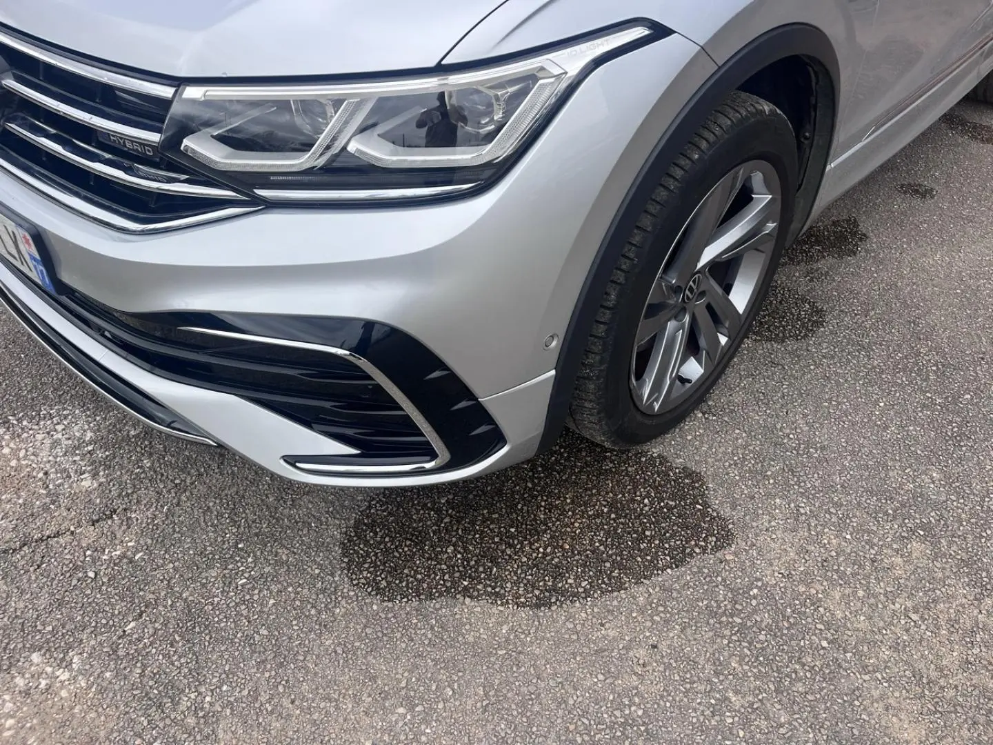 Gros plan sur l'avant droit du Volkswagen Tiguan gris dauphin métallisé avec phares LED et jante alu.